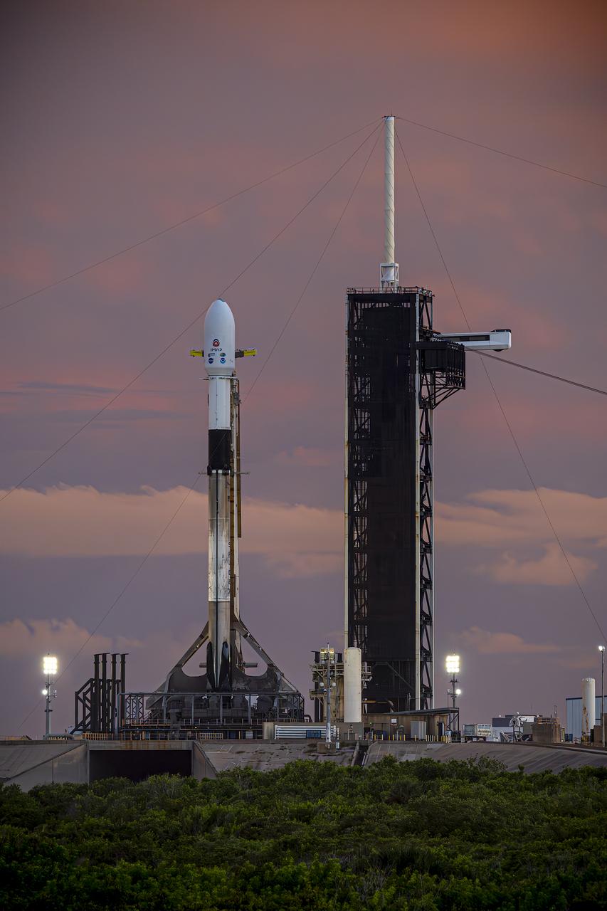 A SpaceX Falcon 9 rocket with NASA’s IMAP (Interstellar Mapping and Acceleration Probe), the agency’s Carruthers Geocorona Observatory, and National Oceanic and Atmospheric Administration’s (NOAA) Space Weather Follow On–Lagrange 1 (SWFO-L1) spacecraft atop stands vertical at Launch Complex 39A as the sun sets on Monday, Sept. 22, 2025, at the agency’s Kennedy Space Center in Florida. The missions will each focus on different effects of the solar wind — the continuous stream of particles emitted by the Sun — and space weather — the changing conditions in space driven by the Sun — from their origins at the Sun to their farthest reaches billions of miles away at the edge of our solar system.