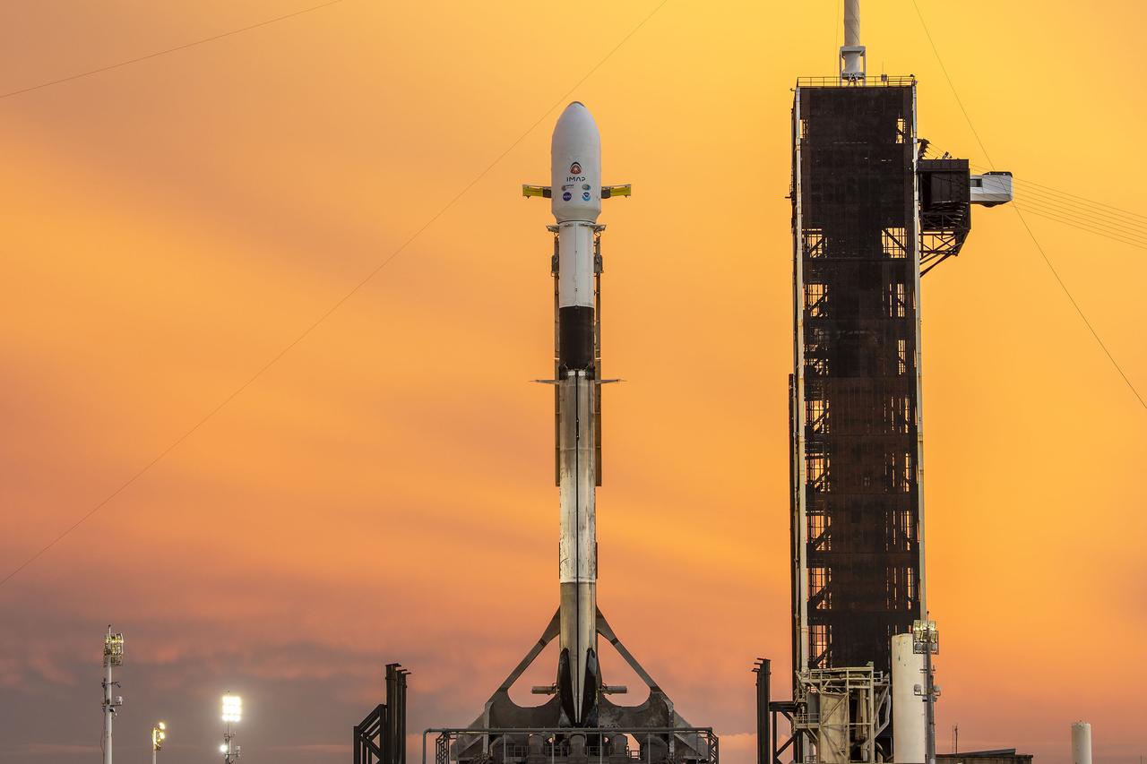 A SpaceX Falcon 9 rocket with NASA’s IMAP (Interstellar Mapping and Acceleration Probe), the agency’s Carruthers Geocorona Observatory, and National Oceanic and Atmospheric Administration’s (NOAA) Space Weather Follow On–Lagrange 1 (SWFO-L1) spacecraft atop stands vertical at Launch Complex 39A as the sun sets on Monday, Sept. 22, 2025, at the agency’s Kennedy Space Center in Florida. The missions will each focus on different effects of the solar wind — the continuous stream of particles emitted by the Sun — and space weather — the changing conditions in space driven by the Sun — from their origins at the Sun to their farthest reaches billions of miles away at the edge of our solar system.
