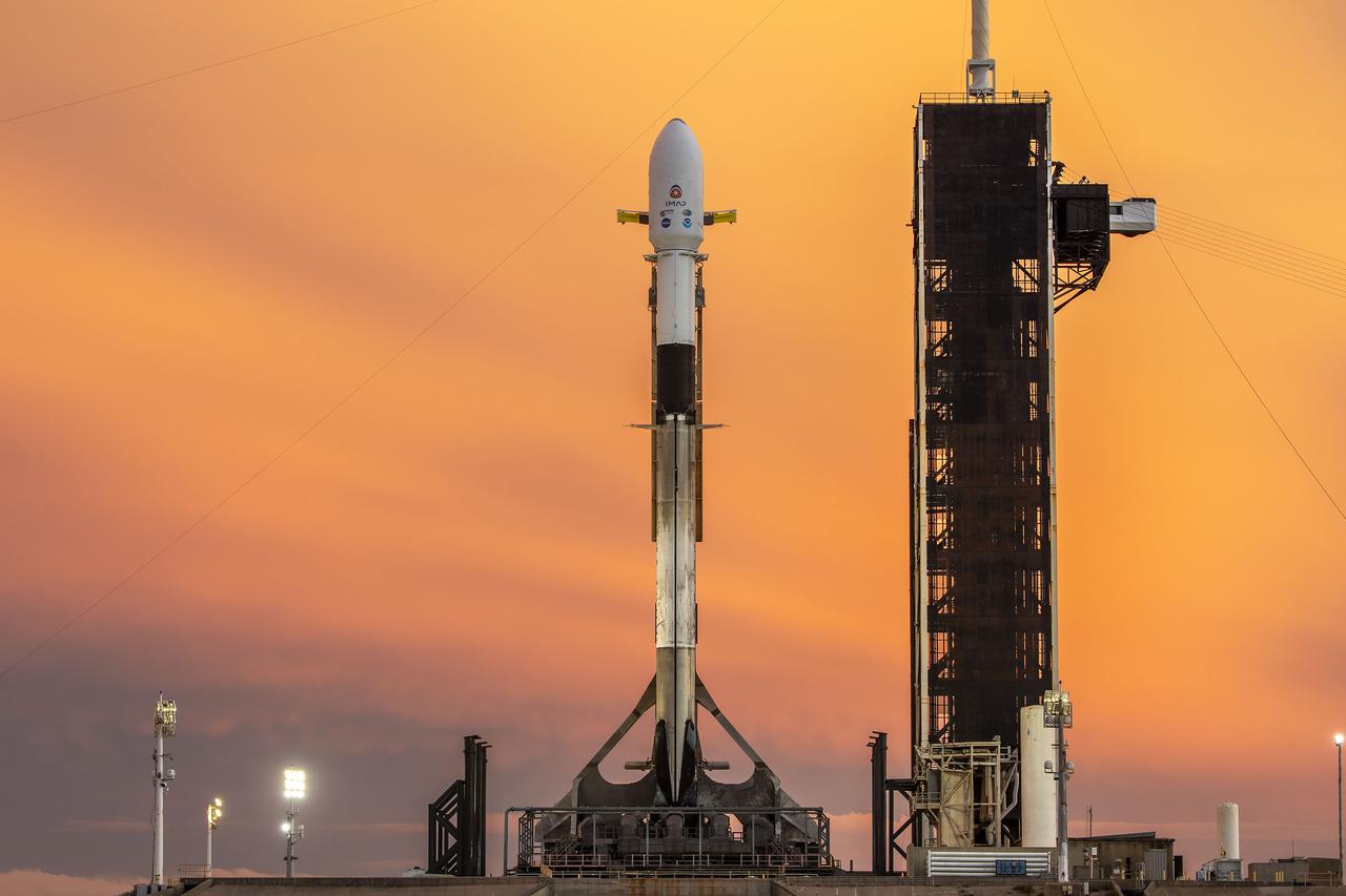 A SpaceX Falcon 9 rocket with NASA’s IMAP (Interstellar Mapping and Acceleration Probe), the agency’s Carruthers Geocorona Observatory, and National Oceanic and Atmospheric Administration’s (NOAA) Space Weather Follow On–Lagrange 1 (SWFO-L1) spacecraft atop stands vertical at Launch Complex 39A as the sun sets on Monday, Sept. 22, 2025, at the agency’s Kennedy Space Center in Florida. The missions will each focus on different effects of the solar wind — the continuous stream of particles emitted by the Sun — and space weather — the changing conditions in space driven by the Sun — from their origins at the Sun to their farthest reaches billions of miles away at the edge of our solar system.