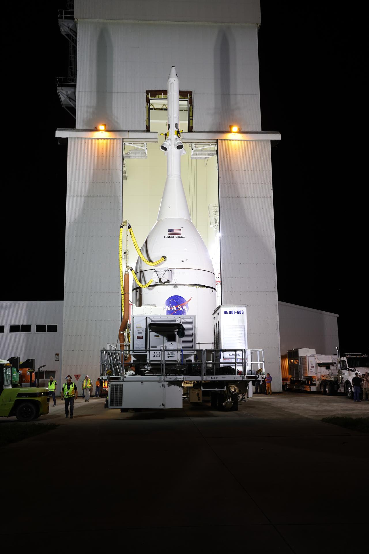 Technicians with NASA’s Exploration Ground Systems team transport NASA’s Orion spacecraft fully assembled with its launch abort system out of the Launch Abort System Facility to the Vehicle Assembly Building at NASA’s Kennedy Space Center in Florida on Thursday, Oct. 16, 2025. Once at the Vehicle Assembly Building, Orion will be stacked atop the SLS (Space Launch System) rocket in High Bay 3 to prepare for the Artemis II mission set to carry NASA astronauts Reid Wiseman, Victor Glover, Christina Koch, and CSA (Canadian Space Agency) astronaut Jeremy Hansen on a 10-day mission around the Moon and back in early 2026.