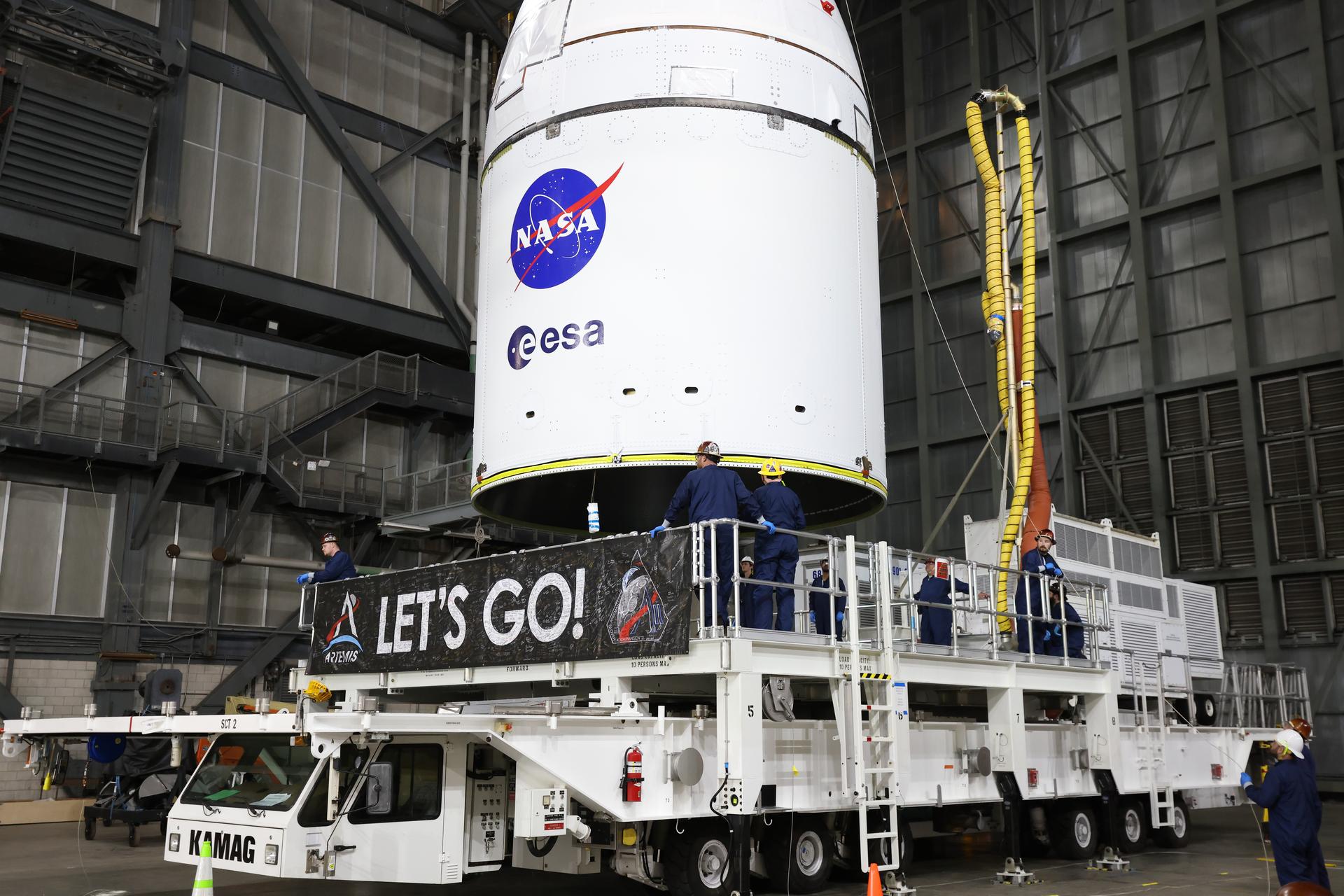 Technicians with NASA’s Exploration Ground Systems team use a crane to lift NASA’s Orion spacecraft off a KAMAG transporter to prepare for integration on top of the SLS (Space Launch System) rocket in High Bay 3 of the Vehicle Assembly Building at NASA’s Kennedy Space Center in Florida on Friday, Oct. 17, 2025, for the agency’s Artemis II mission. Set to launch in 2026, the spacecraft will carry NASA astronauts Reid Wiseman, Victor Glover, Christina Koch, and CSA (Canadian Space Agency) astronaut Jeremy Hansen on a 10-day mission around the Moon and back. Once stacked, teams will begin conducting a series of verification tests ahead of rolling out to Launch Complex 39B for the wet dress rehearsal at NASA Kennedy.