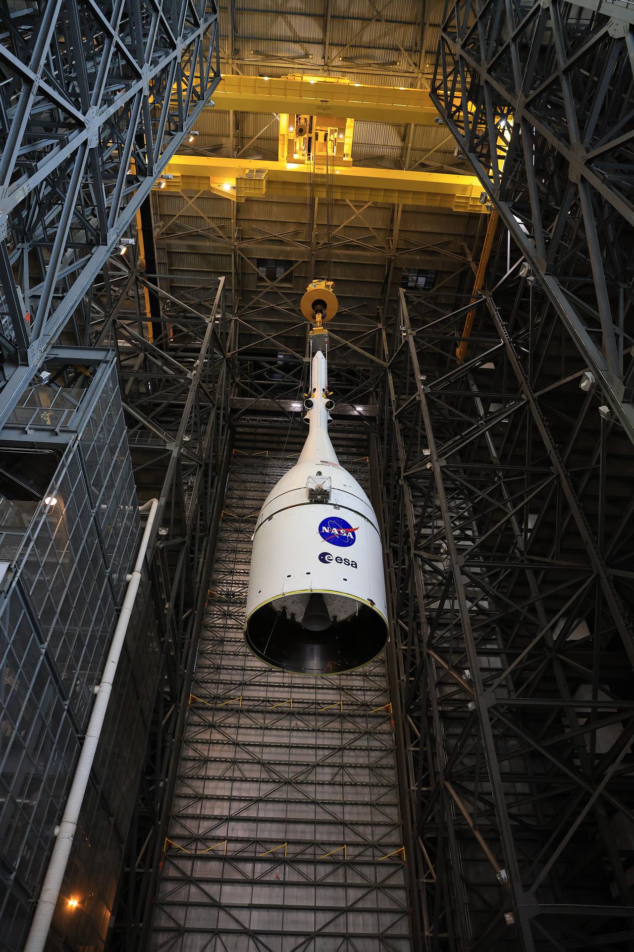 Technicians with NASA’s Exploration Ground Systems team use a crane to lift and secure NASA’s Orion spacecraft on top of the SLS (Space Launch System) rocket in High Bay 3 of the Vehicle Assembly Building at NASA’s Kennedy Space Center in Florida on Saturday, Oct. 18, 2025, for the agency’s Artemis II mission. Set to launch in 2026, the spacecraft will carry NASA astronauts Reid Wiseman, Victor Glover, Christina Koch, and CSA (Canadian Space Agency) astronaut Jeremy Hansen on a 10-day mission around the Moon and back. Once stacked, teams will begin conducting a series of verification tests ahead of rolling out to Launch Complex 39B for the wet dress rehearsal at NASA Kennedy. 