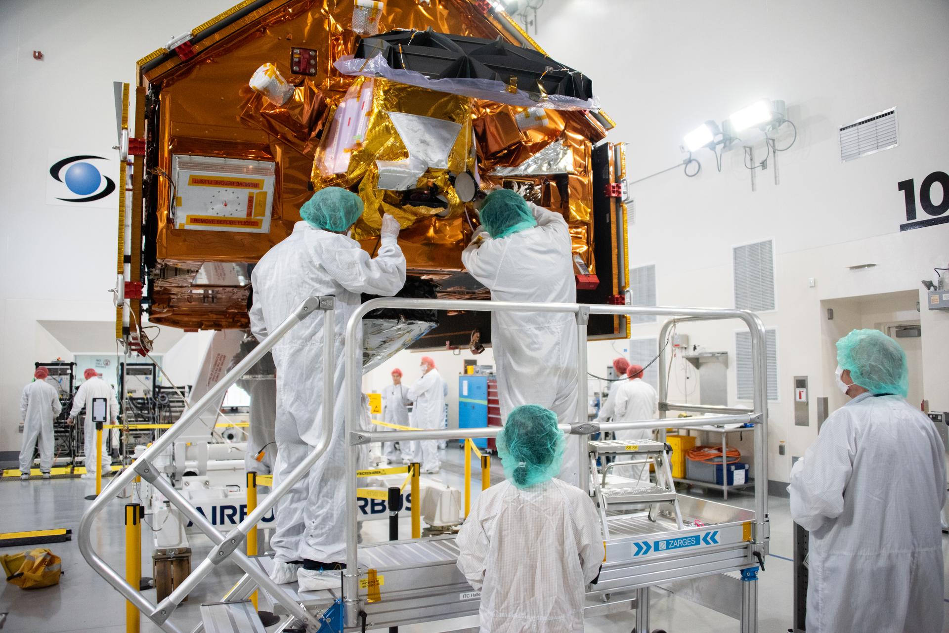 Technicians install multi-layer insulation on the Sentinel-6B spacecraft on a work stand inside the Astrotech Space Operations payload processing facility at Vandenberg Space Force Base in California on Thursday, Oct. 23, 2025. Critical for protecting spacecraft from extreme temperatures and environmental conditions in space, the thin, reflective multi-layer insulation will create a barrier to help reduce heat transfer through radiation while Sentinel-6B is in orbit. A collaboration between NASA, ESA (European Space Agency), EUMETSAT (European Organisation for the Exploitation of Meteorological Satellites), and the National Oceanic and Atmospheric Administration (NOAA), Sentinel-6B is designed to measure sea levels down to roughly an inch for about 90% of the world’s oceans. NASA is targeting launch no earlier than Sunday, Nov. 16, 2025, on a SpaceX Falcon 9 rocket from Space Launch Complex 4 East at Vandenberg.