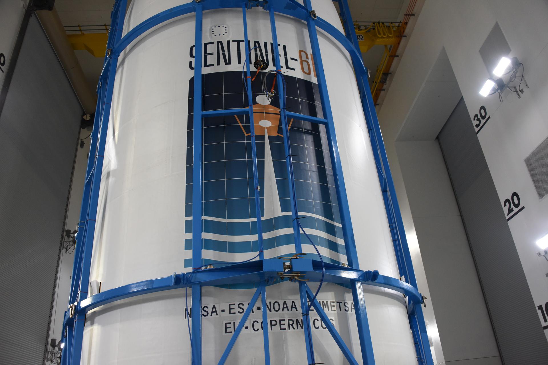 Technicians and engineers encapsulate the Sentinel-6B spacecraft within a protective payload fairing inside the Astrotech Space Operations facility at Vandenberg Space Force Base in California, on Monday, Nov. 10, 2025. A collaboration between NASA, ESA (European Space Agency), EUMETSAT (European Organisation for the Exploitation of Meteorological Satellites), and the National Oceanic and Atmospheric Administration (NOAA), Sentinel-6B is designed to measure sea levels down to roughly an inch for about 90% of the world’s oceans. NASA is targeting launch no earlier than Sunday, Nov. 16, on a SpaceX Falcon 9 rocket from Space Launch Complex 4 East at Vandenberg.