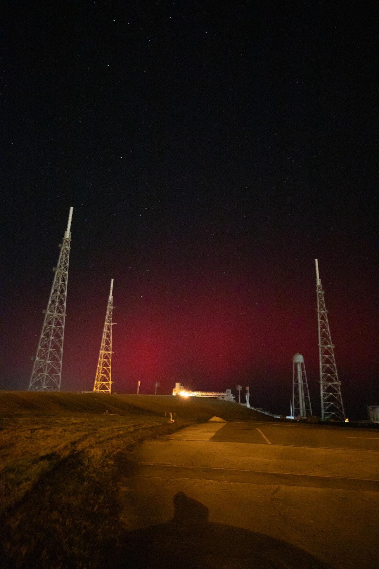 The faint glow of an aurora is seen over Launch Complex 39B at NASA’s Kennedy Space Center in Florida on Tuesday, Nov. 11, 2025. Auroras are created by energetic electrons, which rain down from Earth’s magnetic bubble and interact with particles in the upper atmosphere to create glowing lights that stretch across the sky.