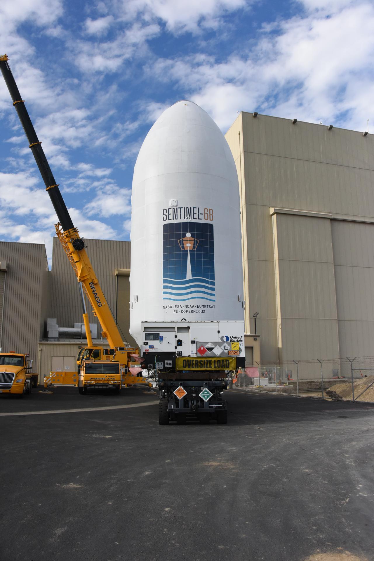 Workers transport the international Sentinel-6B satellite, encapsulated in the SpaceX Falcon 9 payload fairing, from the Astrotech Space Operations Facility to Space Launch Complex 4 East at Vandenberg Space Force Base in California on Wednesday, Nov. 12, 2025. A collaboration between NASA, ESA (European Space Agency), EUMETSAT (European Organisation for the Exploitation of Meteorological Satellites), and the National Oceanic and Atmospheric Administration (NOAA), Sentinel-6B is designed to measure sea levels down to roughly an inch for about 90% of the world’s oceans. NASA is targeting Sunday, Nov. 16, 2025, for launch.