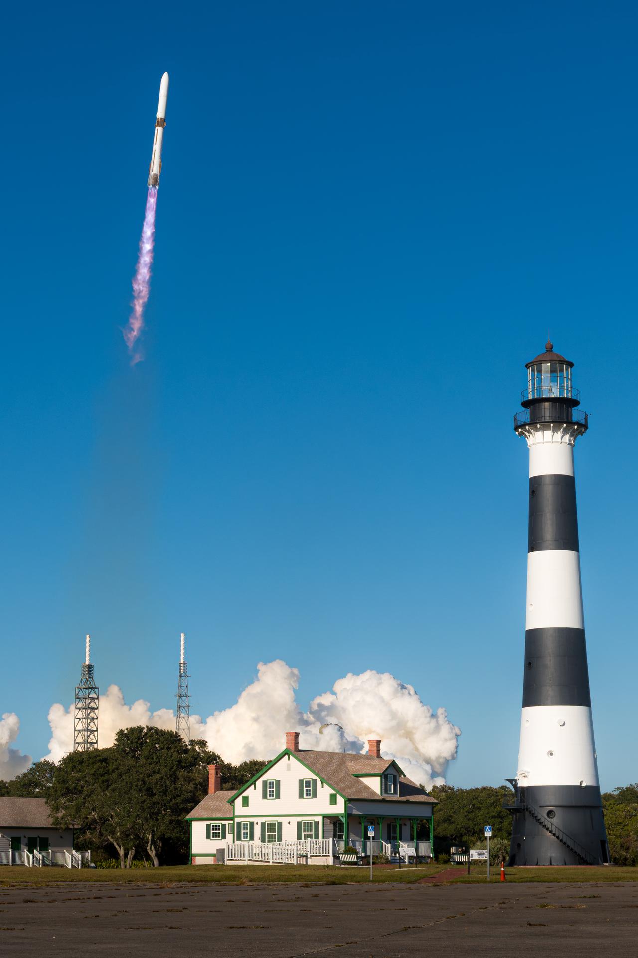 Image shows Blue Origin's New Glenn rocket launching from Launch Complex 36 at Cape Canaveral Space Force Station surrounded by blue clear skies and a lighthouse in the foreground. Photo credit: Blue Origin