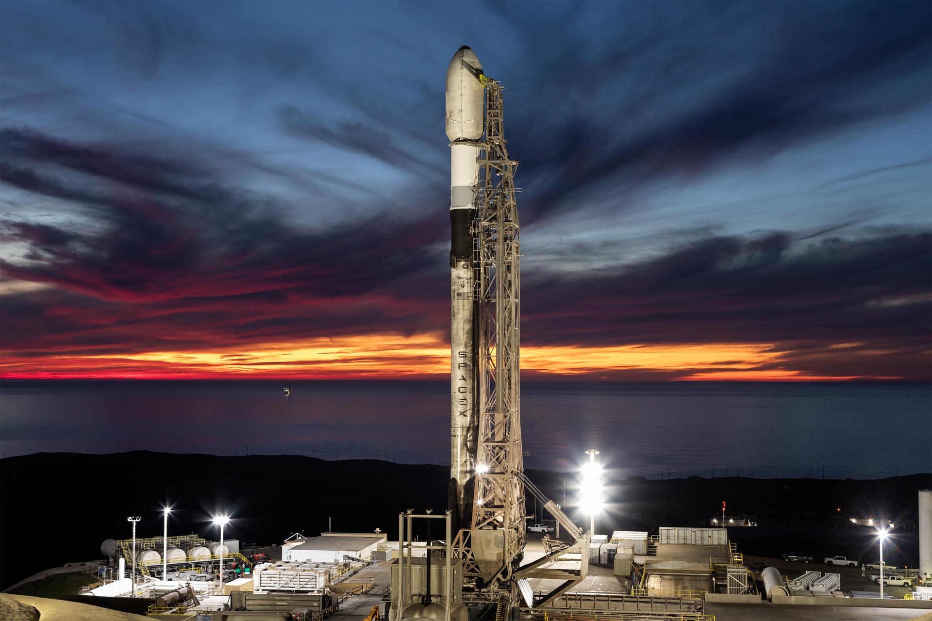 Image shows A SpaceX Falcon 9 rocket carrying NASA’s R5-S7 (Realizing Rapid, Reduced-cost high-Risk Research project Spacecraft 7) CubeSat along with several other satellites as part of the company’s Transporter-15 mission stands vertical on the launch pad of Space Launch Complex 4 East at Vandenberg Space Force Base in California on Thursday, Nov. 27, 2025. The latest in a series of spacecraft, R5-S7 will explore ways to get multiple technology prototypes into low Earth orbit rapidly and at a low cost, accelerating the demonstration of these technologies in orbit and allowing engineers and scientists to more quickly prove them and make them available to NASA missions and other users.