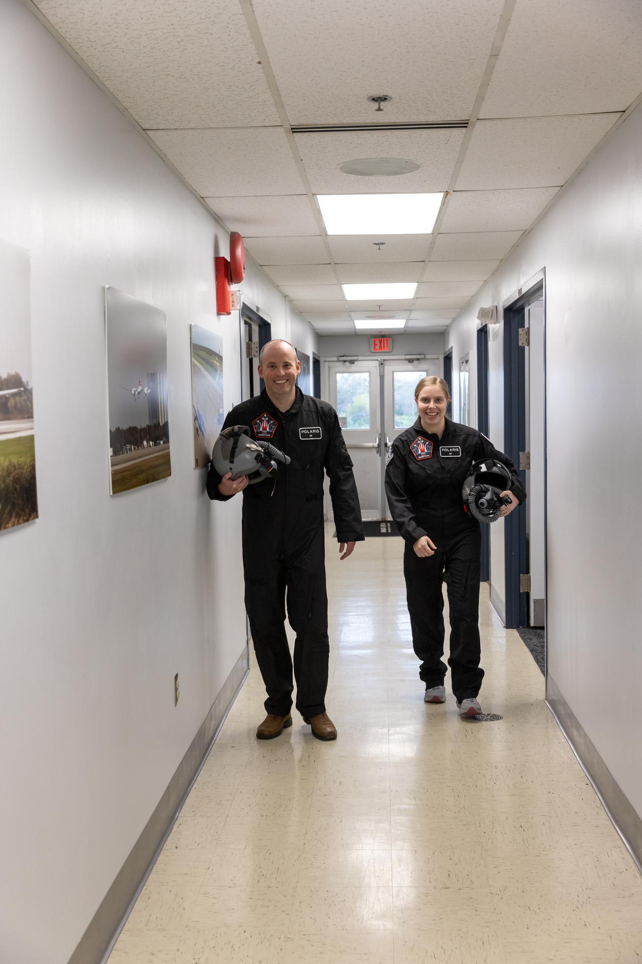From left to right, Daniel Forrestel, manager, Ground and Missions Operations Office of NASA’s Commercial Crew Program and Ashley Scharfenberg, Systems Engineering and Integration for Exploration Ground Systems, walk in their flight suits at NASA’s Kennedy Space Center in Florida on Tuesday, Jan. 13, 2026. NASA Administrator Jared Isaacman flew Forrestel and Scharfenberg on an employee incentive in Isaacman’s personal Northrop F-5 Tiger II aircraft around NASA Kennedy. As the newly appointed 15th administrator of the agency, Isaacman created a ride-along program to recognize and reward members of the workforce for their dedication to accomplishing agency priorities. 