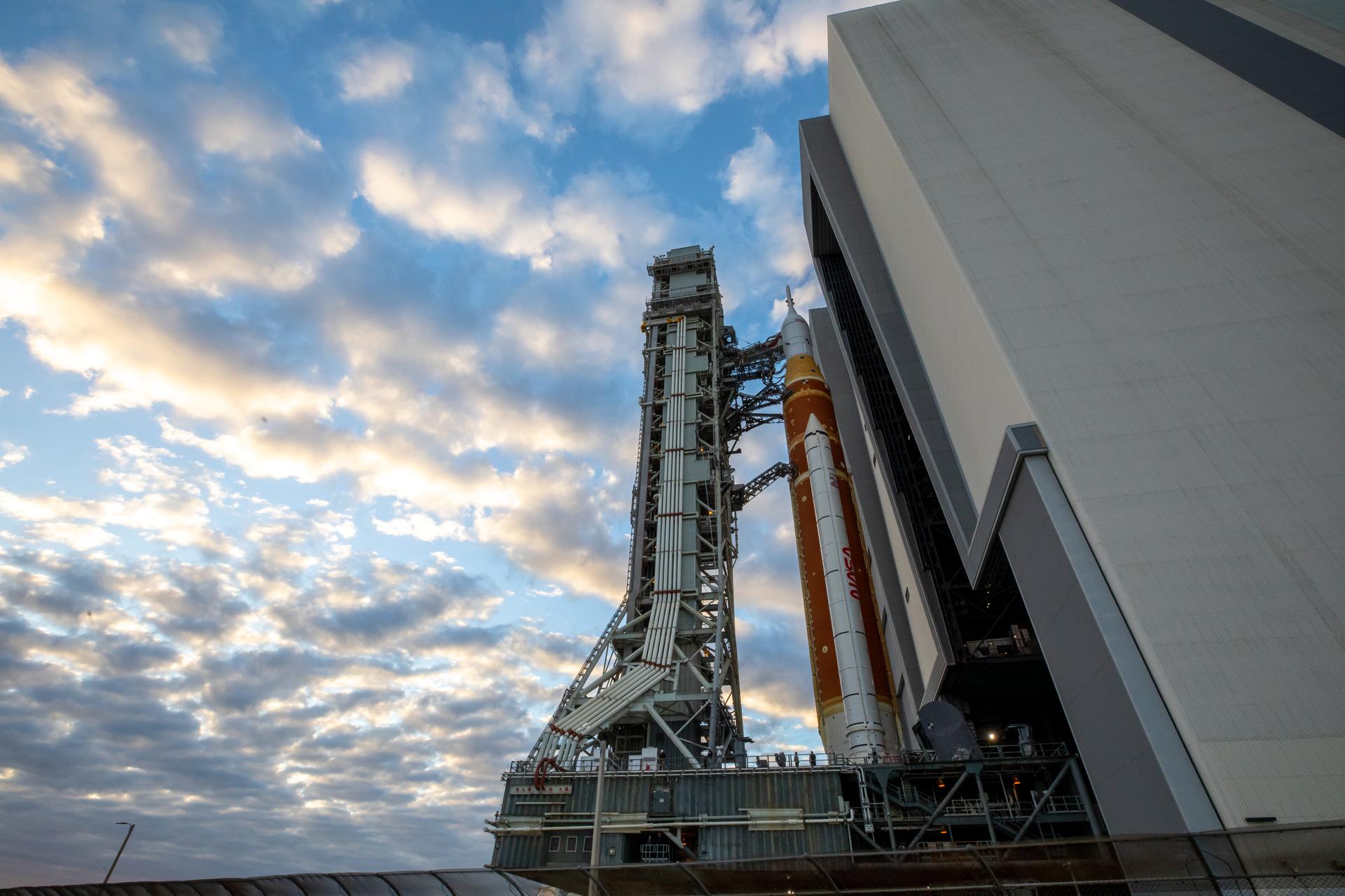 NASA’s crawler-transporter 2 carrying the agency’s Artemis II SLS (Space Launch System) rocket and Orion spacecraft, secured to the mobile launcher, begins rolling out from High Bay 3 inside the Vehicle Assembly Building to Launch Complex 39B at NASA’s Kennedy Space Center in Florida on Saturday, Jan. 17, 2026. The Artemis II test flight will take Commander Reid Wiseman, Pilot Victor Glover, and Mission Specialist Christina Koch from NASA and Mission Specialist Jeremy Hansen from the CSA (Canadian Space Agency), around the Moon and back to Earth no later than April 2026.
