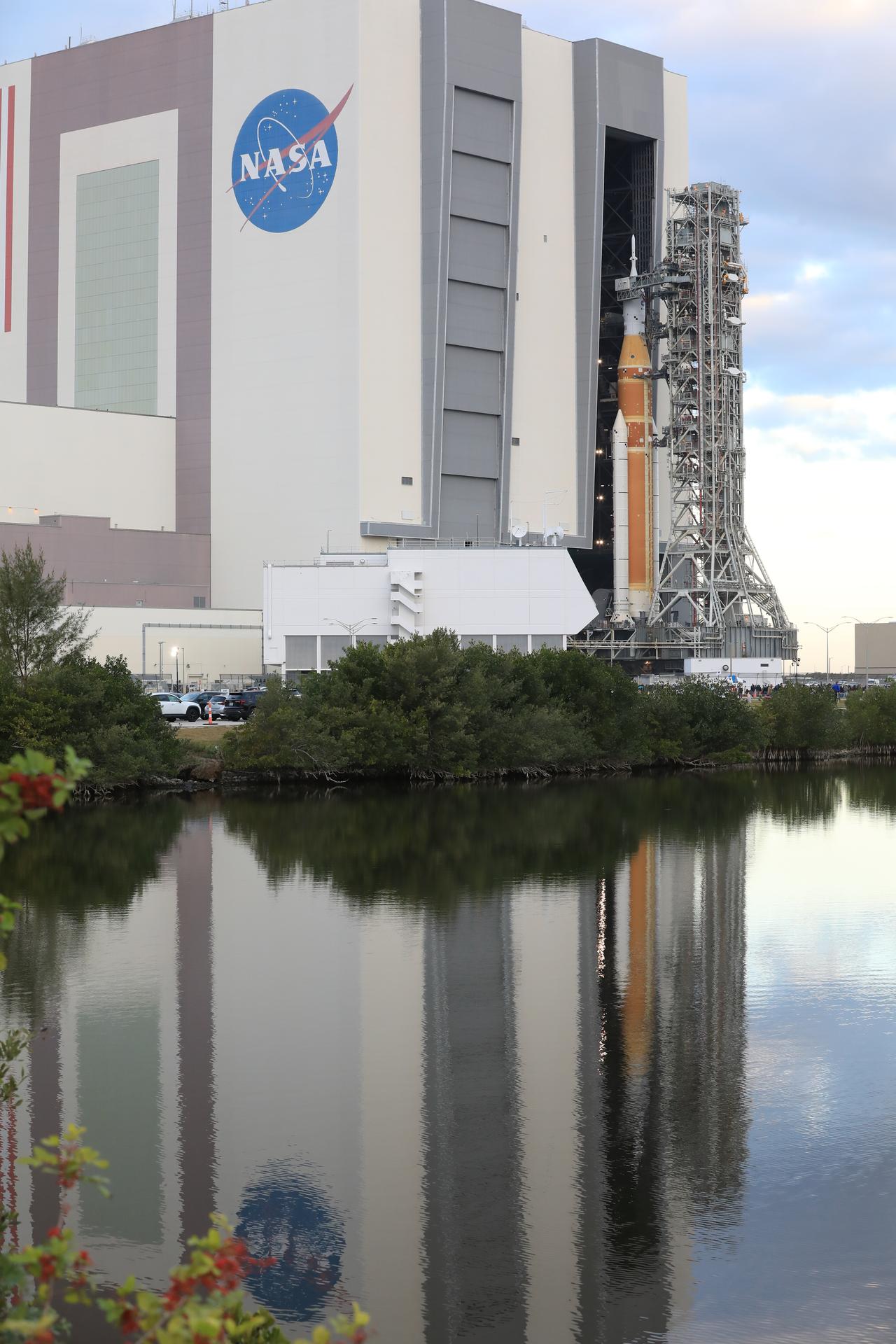 NASA’s crawler-transporter 2 carrying the agency’s Artemis II SLS (Space Launch System) rocket and Orion spacecraft, secured to the mobile launcher, begins rolling out from High Bay 3 inside the Vehicle Assembly Building to Launch Complex 39B at NASA’s Kennedy Space Center in Florida on Saturday, Jan. 17, 2026. The Artemis II test flight will take Commander Reid Wiseman, Pilot Victor Glover, and Mission Specialist Christina Koch from NASA and Mission Specialist Jeremy Hansen from the CSA (Canadian Space Agency), around the Moon and back to Earth no later than April 2026. 