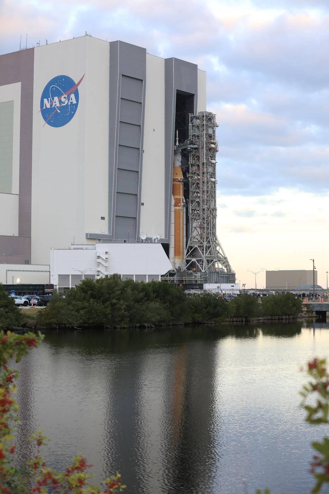NASA’s crawler-transporter 2 carrying the agency’s Artemis II SLS (Space Launch System) rocket and Orion spacecraft, secured to the mobile launcher, begins rolling out from High Bay 3 inside the Vehicle Assembly Building to Launch Complex 39B at NASA’s Kennedy Space Center in Florida on Saturday, Jan. 17, 2026. The Artemis II test flight will take Commander Reid Wiseman, Pilot Victor Glover, and Mission Specialist Christina Koch from NASA and Mission Specialist Jeremy Hansen from the CSA (Canadian Space Agency), around the Moon and back to Earth no later than April 2026. 