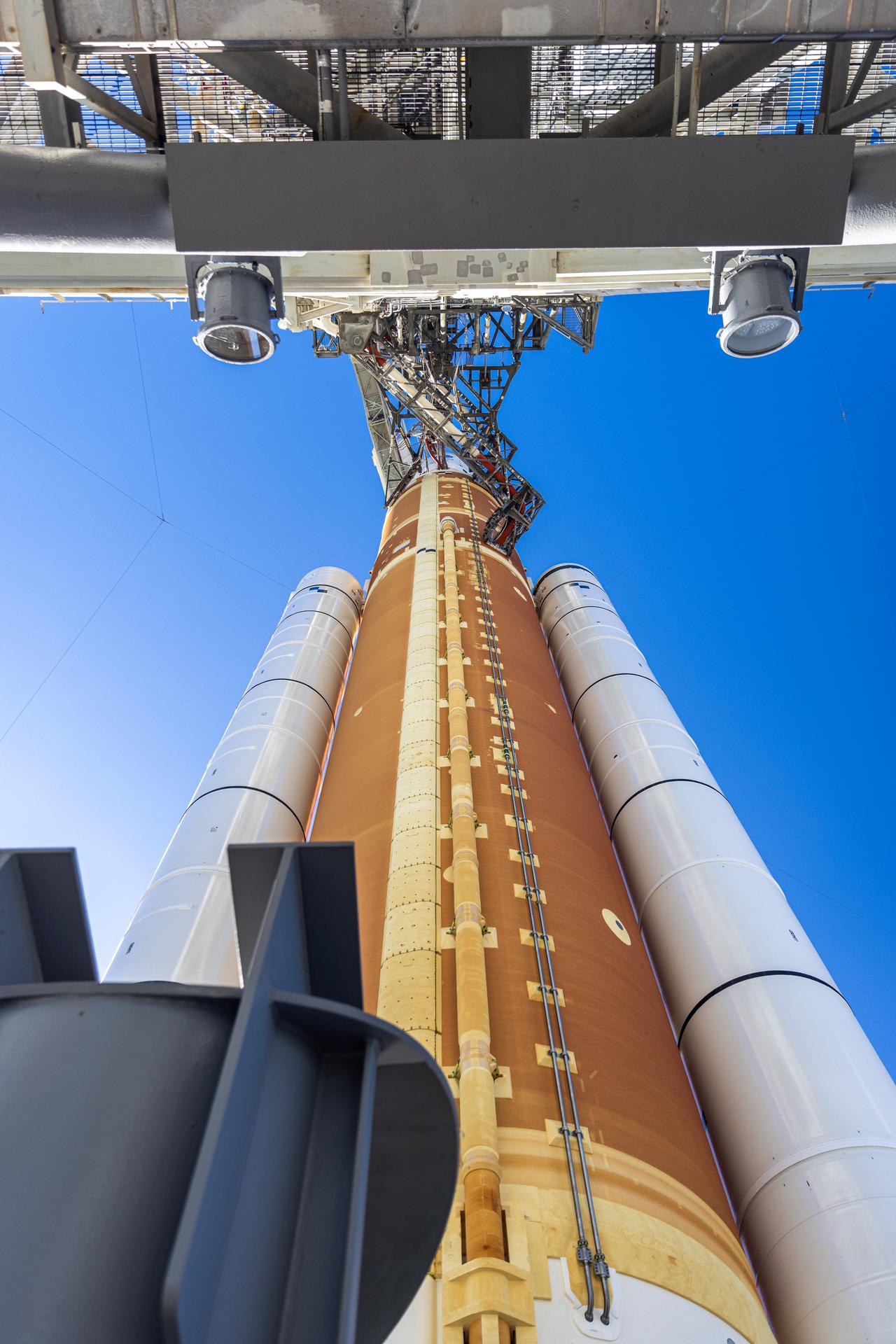 In this angle looking up, this photograph shows the crew access arm connected to NASA’s Artemis II SLS (Space Launch System) rocket and Orion spacecraft, secured to the mobile launcher at Launch Complex 39B at NASA’s Kennedy Space Center in Florida on Tuesday, Jan. 20, 2026. The Artemis II test flight will take Commander Reid Wiseman, Pilot Victor Glover, and Mission Specialist Christina Koch from NASA, and Mission Specialist Jeremy Hansen from the CSA (Canadian Space Agency), on a 10-day journey no earlier than 6:24 p.m. EDT on Wednesday, April 1. 