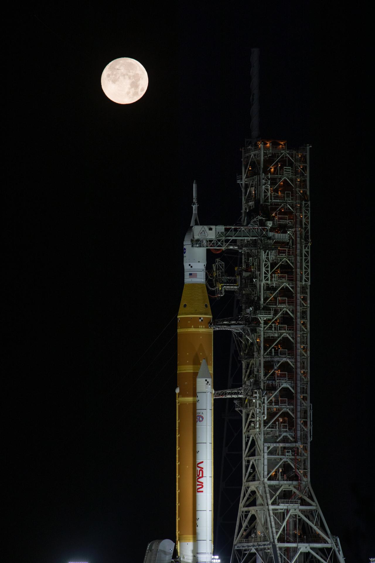 The Moon rises behind NASA’s Artemis II SLS (Space Launch System) rocket and Orion spacecraft atop a mobile launcher at Launch Complex 39B at NASA’s Kennedy Space Center in Florida on Sunday, Feb. 1,. 2026. The Artemis II test flight will take Commander Reid Wiseman, Pilot Victor Glover, and Mission Specialist Christina Koch from NASA, and Mission Specialist Jeremy Hansen from the CSA (Canadian Space Agency), around the Moon and back to Earth.