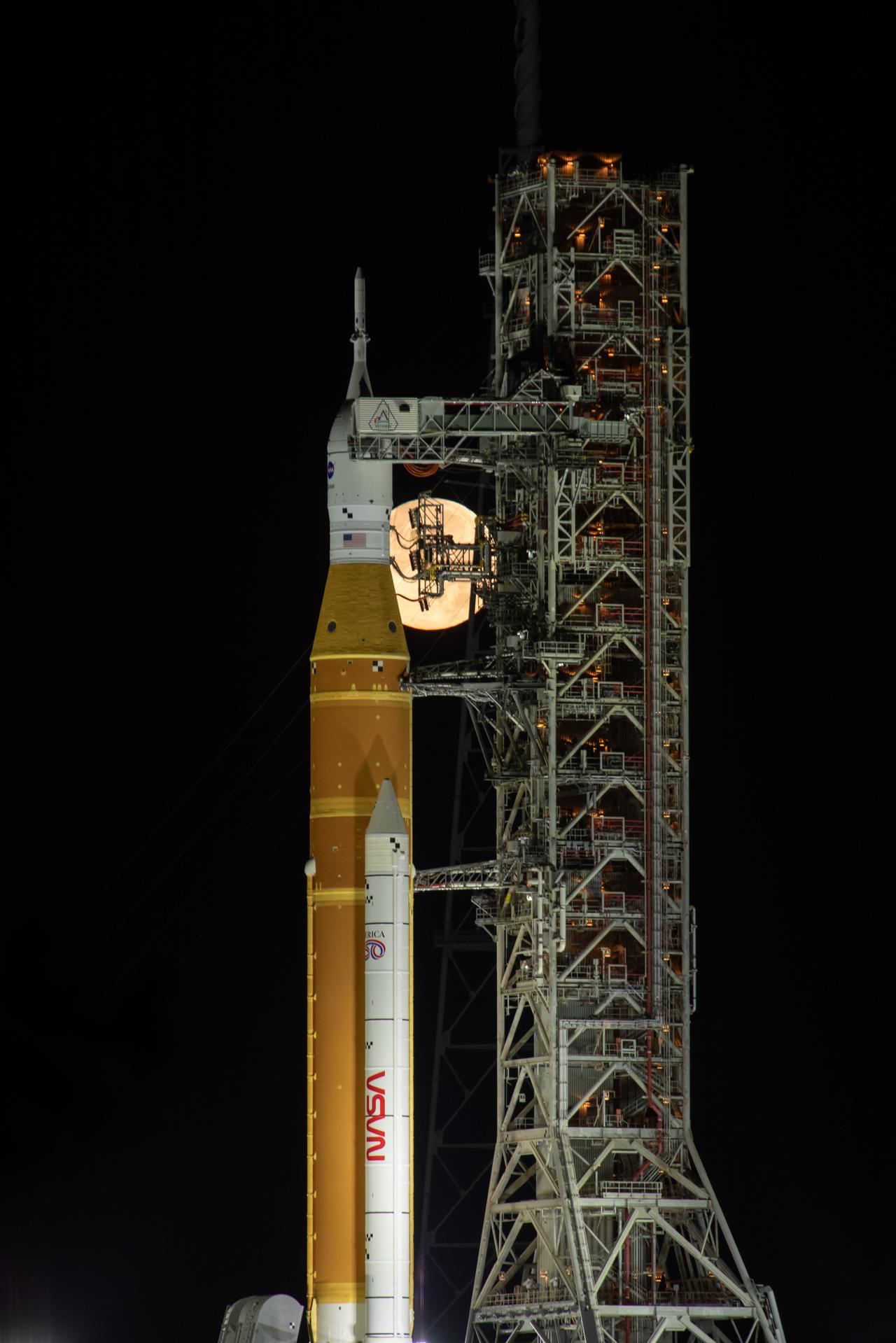 The Moon rises behind NASA’s Artemis II SLS (Space Launch System) rocket and Orion spacecraft atop a mobile launcher at Launch Complex 39B at NASA’s Kennedy Space Center in Florida on Sunday, Feb. 1,. 2026. The Artemis II test flight will take Commander Reid Wiseman, Pilot Victor Glover, and Mission Specialist Christina Koch from NASA, and Mission Specialist Jeremy Hansen from the CSA (Canadian Space Agency), around the Moon and back to Earth.