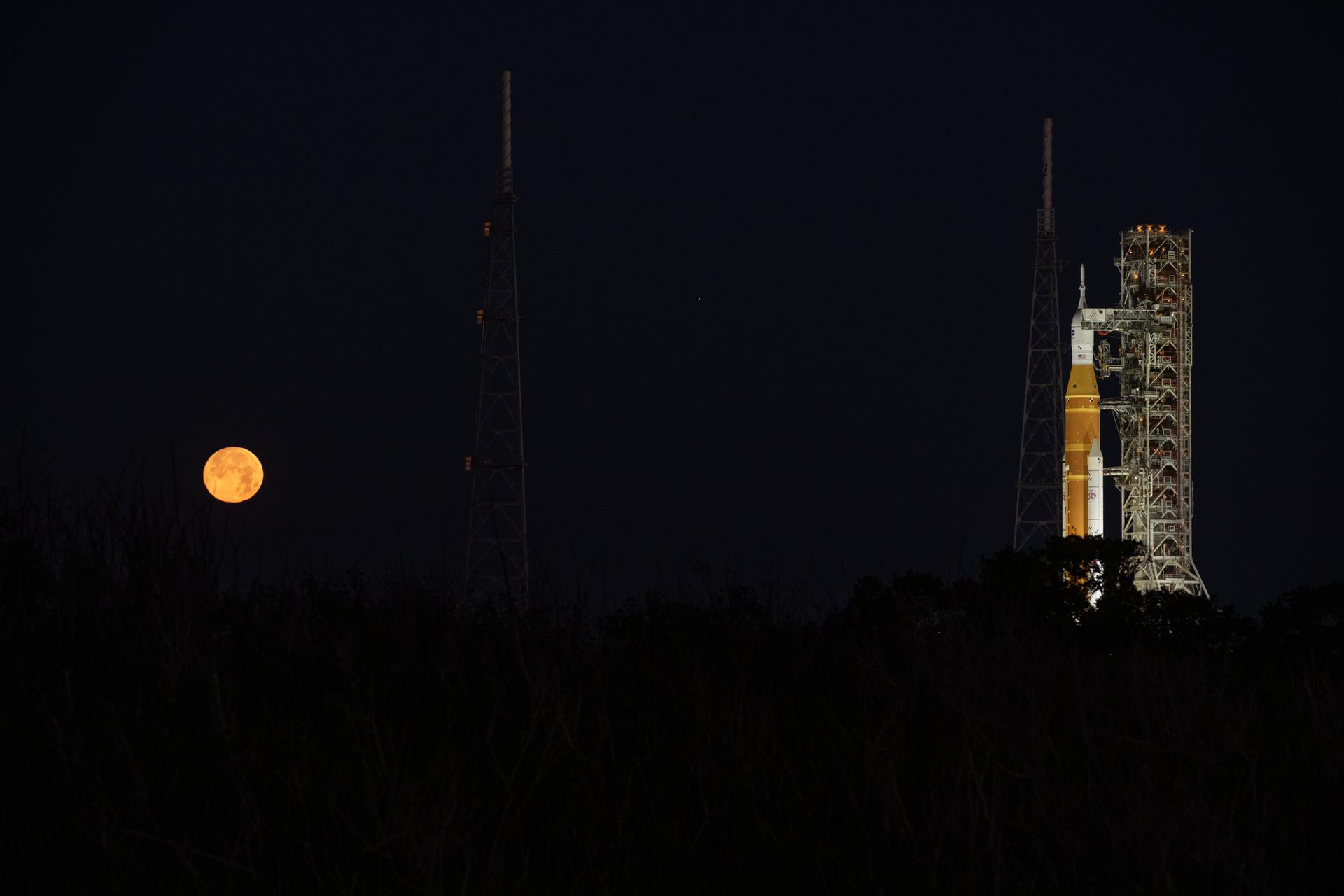 The Moon rises behind NASA’s Artemis II SLS (Space Launch System) rocket and Orion spacecraft atop a mobile launcher at Launch Complex 39B at NASA’s Kennedy Space Center in Florida on Sunday, Feb. 1,. 2026. The Artemis II test flight will take Commander Reid Wiseman, Pilot Victor Glover, and Mission Specialist Christina Koch from NASA, and Mission Specialist Jeremy Hansen from the CSA (Canadian Space Agency), around the Moon and back to Earth.