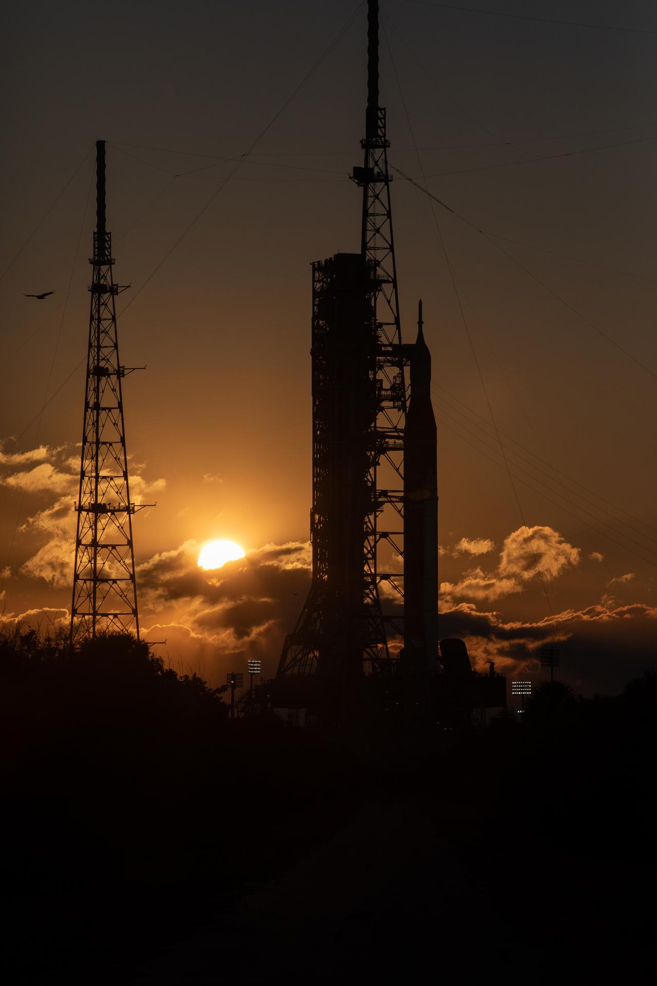 The Sun rises behind NASA’s Artemis II SLS (Space Launch System) rocket and Orion spacecraft atop a mobile launcher at Launch Complex 39B at NASA’s Kennedy Space Center in Florida on Sunday, Feb. 1, 2026. The Artemis II test flight will take Commander Reid Wiseman, Pilot Victor Glover, and Mission Specialist Christina Koch from NASA, and Mission Specialist Jeremy Hansen from the CSA (Canadian Space Agency), around the Moon and back to Earth.