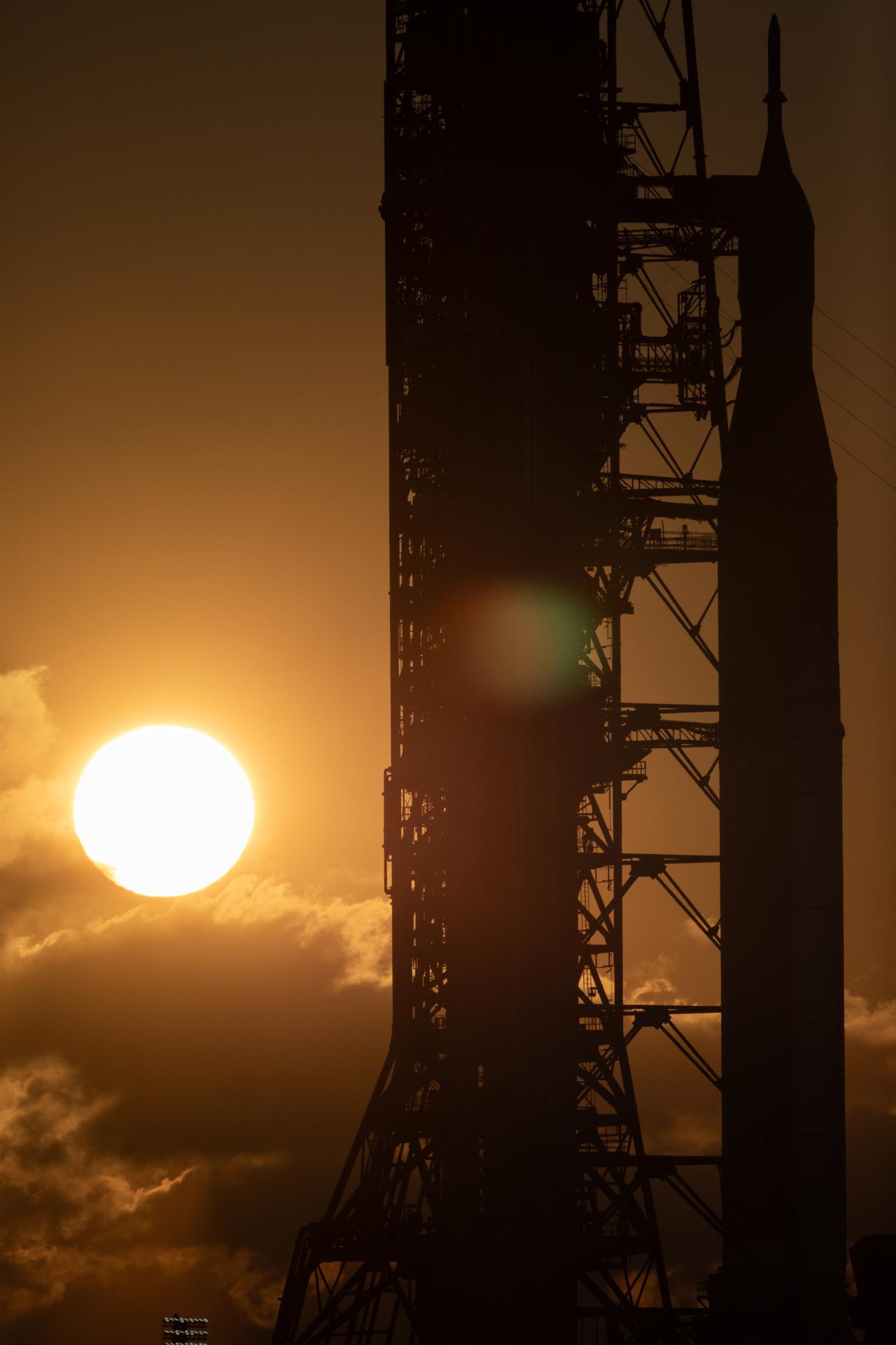 The Sun rises behind NASA’s Artemis II SLS (Space Launch System) rocket and Orion spacecraft atop a mobile launcher at Launch Complex 39B at NASA’s Kennedy Space Center in Florida on Sunday, Feb. 1, 2026. The Artemis II test flight will take Commander Reid Wiseman, Pilot Victor Glover, and Mission Specialist Christina Koch from NASA, and Mission Specialist Jeremy Hansen from the CSA (Canadian Space Agency), around the Moon and back to Earth.