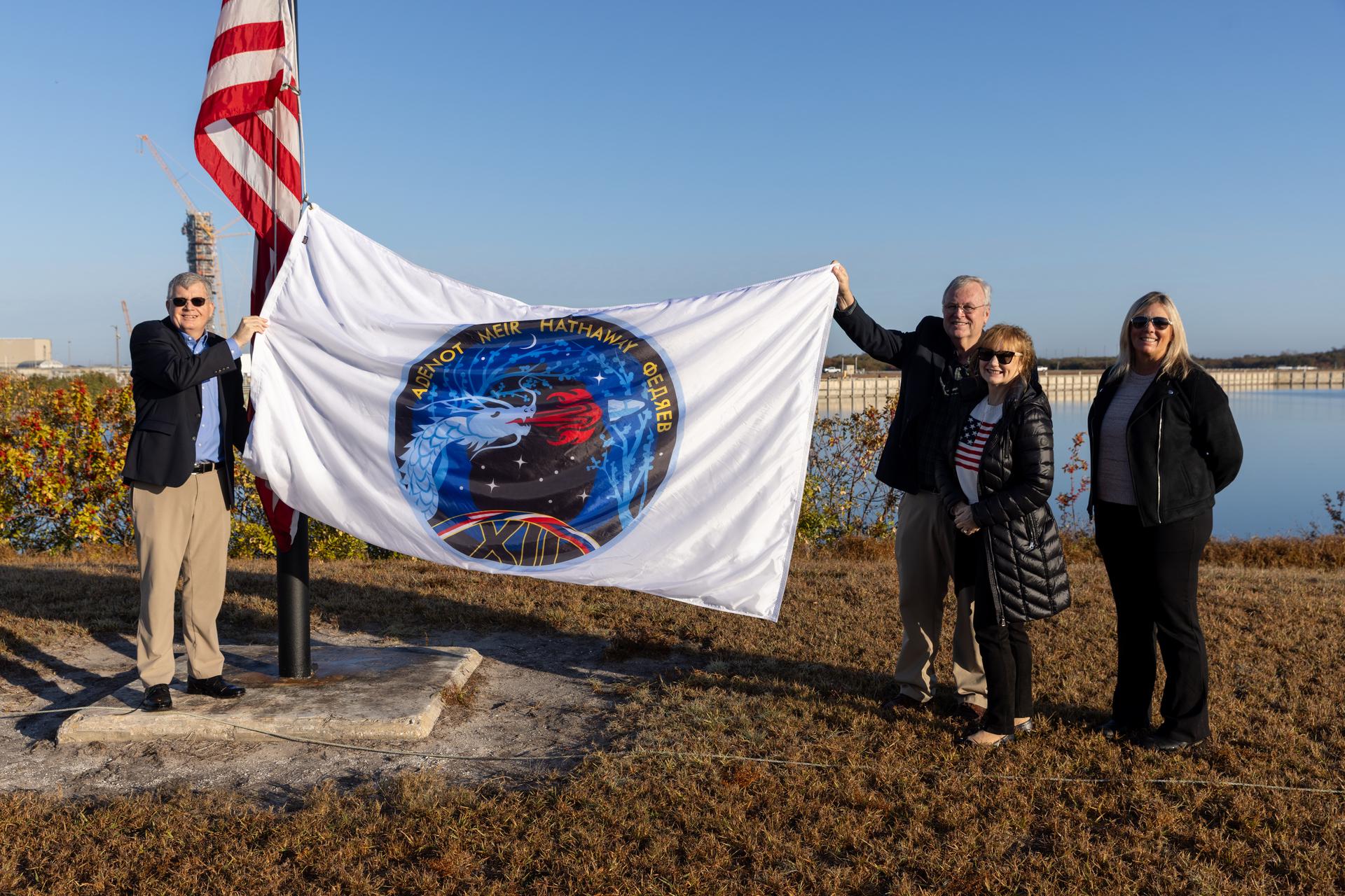 From left, Steve Stich, manager, NASA’s Commercial Crew Program; Steve Sullivan, chief engineer to NASA’s Commercial Crew Program; Jackie Sullivan; and Dana Hutcherson, deputy program manager, NASA’s Commercial Crew Program, participate in raising the agency’s SpaceX Crew-12 mission flag near the countdown clock at the NASA News Center at the agency’s Kennedy Space Center in Florida on Monday, Feb. 9, 2026. The Crew-12 mission will send NASA astronauts Jessica Meir and Jack Hathaway, ESA (European Space Agency) astronaut Sophie Adenot, and Roscosmos cosmonaut Andrey Fedyaev to the International Space Station aboard SpaceX’s Dragon spacecraft and Falcon 9 rocket no earlier than 5:38 a.m. EST, Thursday, Feb. 12, from Cape Canaveral Space Force Station’s Space Launch Complex 40.