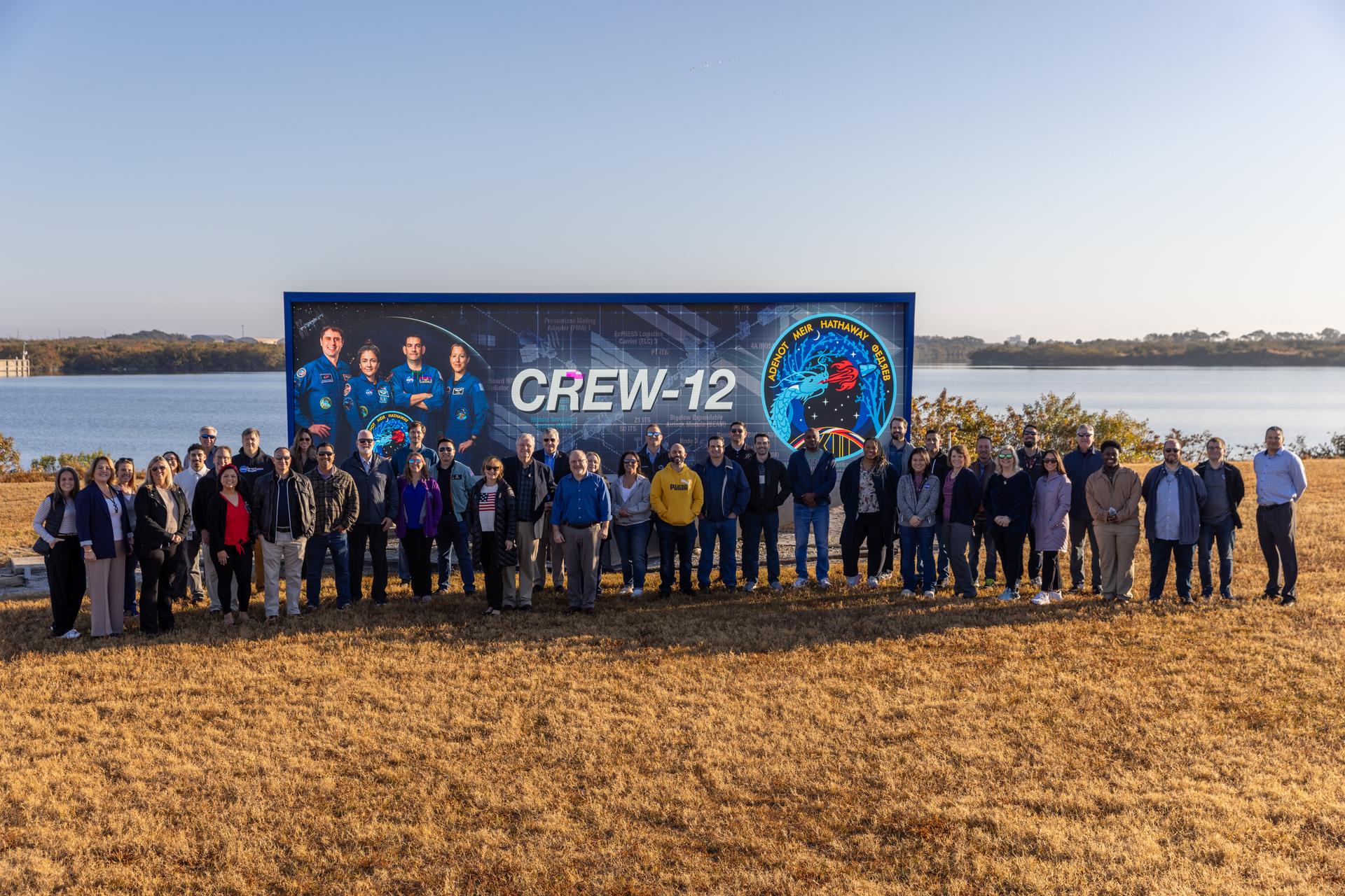 NASA Commercial Crew Program employees raise the agency’s SpaceX Crew-12 mission flag near the countdown clock at the NASA News Center at the agency’s Kennedy Space Center in Florida on Monday, Feb. 9, 2026. The Crew-12 mission will send NASA astronauts Jessica Meir and Jack Hathaway, ESA (European Space Agency) astronaut Sophie Adenot, and Roscosmos cosmonaut Andrey Fedyaev to the International Space Station aboard SpaceX’s Dragon spacecraft and Falcon 9 rocket no earlier than 5:38 a.m. EST, Thursday, Feb. 12, from Cape Canaveral Space Force Station’s Space Launch Complex 40.