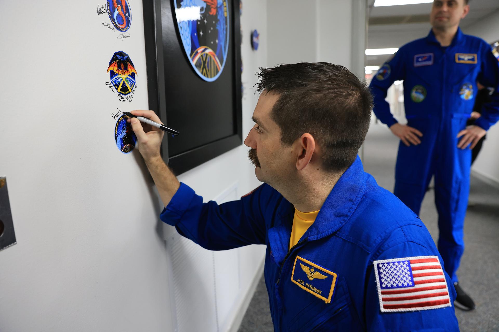 NASA astronaut Jack Hathaway signs his name next to the Crew-12 mission insignia inside the Astronaut Crew Quarters in the Neil A. Armstrong Operations and Checkout Building at NASA’s Kennedy Space Center in Florida on Monday, Feb. 9, 2026, ahead of NASA’s SpaceX Crew-12 mission. A SpaceX Dragon spacecraft and Falcon 9 rocket will send NASA astronauts Hathaway and Jessica Meir, ESA (European Space Agency) astronaut Sophie Adenot, and Roscosmos cosmonaut Andrey Fedyaev to the International Space Station no earlier than 5:15 a.m. EST on Friday, Feb. 13, from Cape Canaveral Space Force Station’s Space Launch Complex 40.