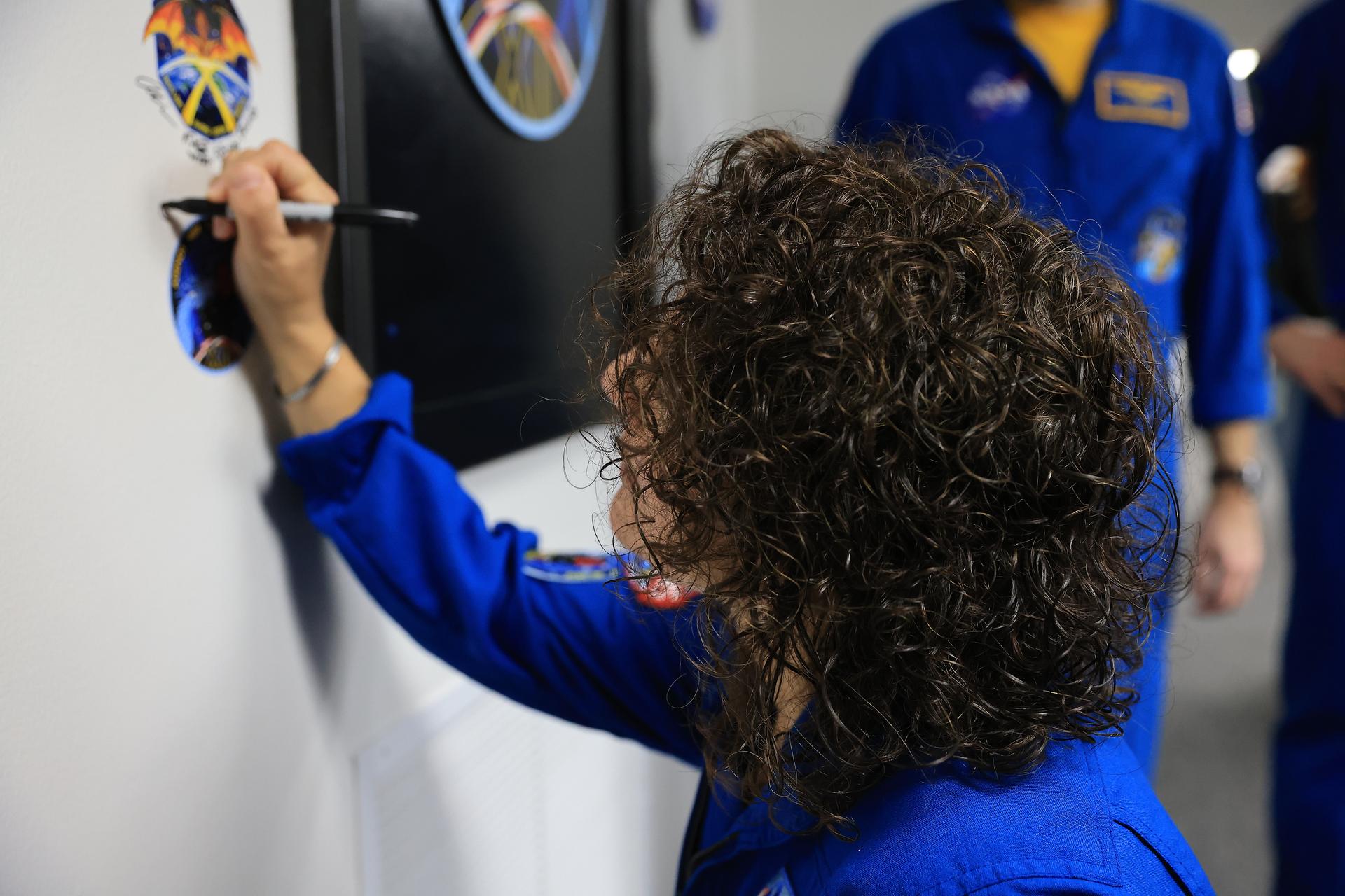 NASA astronaut Jessica Meir signs her name next to the Crew-12 mission insignia inside the Astronaut Crew Quarters in the Neil A. Armstrong Operations and Checkout Building at NASA’s Kennedy Space Center in Florida on Monday, Feb. 9, 2026, ahead of NASA’s SpaceX Crew-12 mission. A SpaceX Dragon spacecraft and Falcon 9 rocket will send NASA astronauts Meir and Jack Hathaway, ESA (European Space Agency) astronaut Sophie Adenot, and Roscosmos cosmonaut Andrey Fedyaev to the International Space Station no earlier than 5:15 a.m. EST on Friday, Feb. 13, from Cape Canaveral Space Force Station’s Space Launch Complex 40.