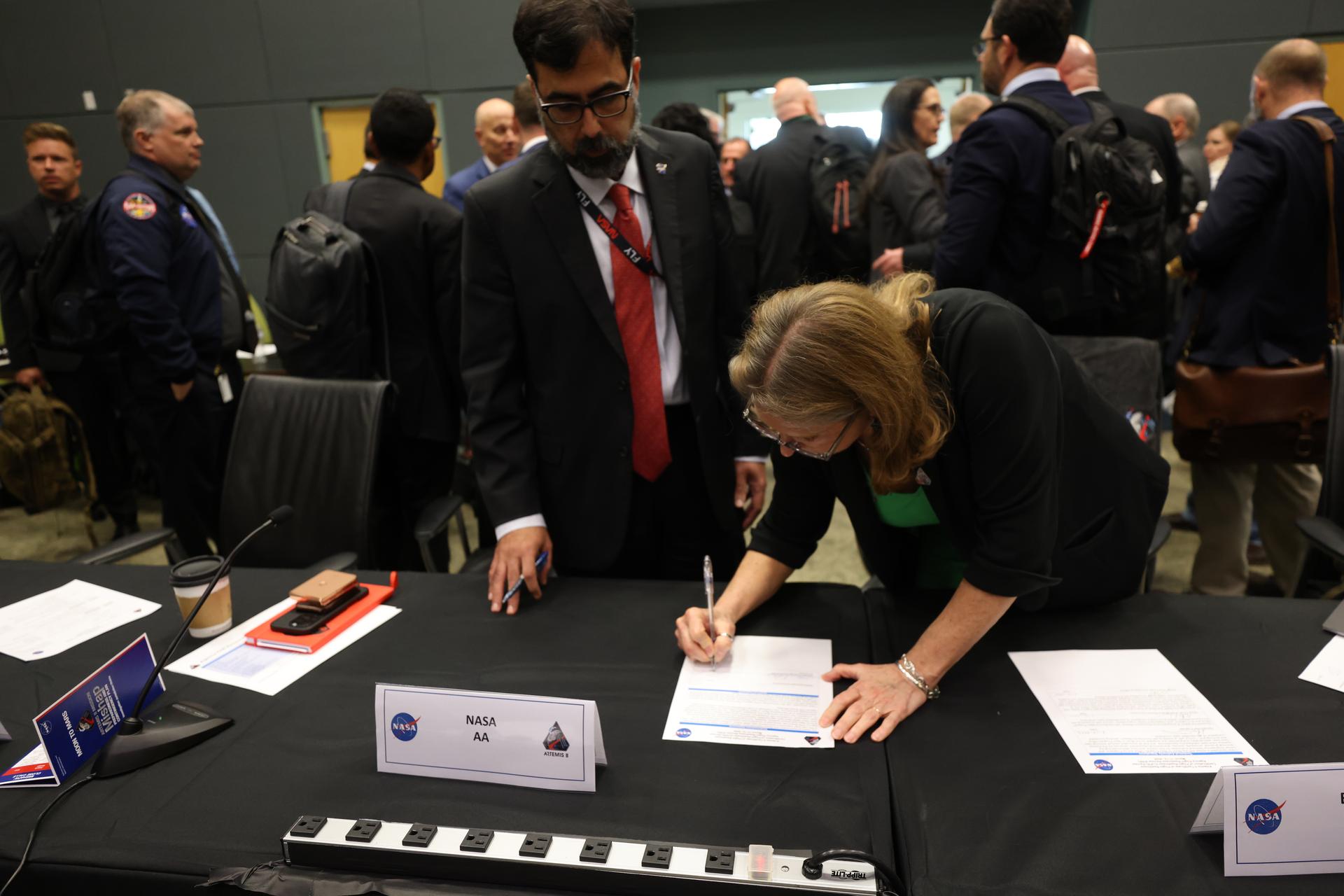 With NASA Associate Administrator Amit Kshatriya looking on, Lori Glaze, acting associate administrator, Exploration Systems Development Mission Directorate, signs the certification for flight readiness following the completion of the Flight Readiness Review for the Artemis II test flight on Thursday, March 12, 2026, at NASA’s Kennedy Space Center in Florida. The review is an assessment of the readiness of NASA’s SLS (Space Launch System) rocket and Orion spacecraft to support the Artemis II test flight as four astronauts journey around the Moon and return to Earth. 