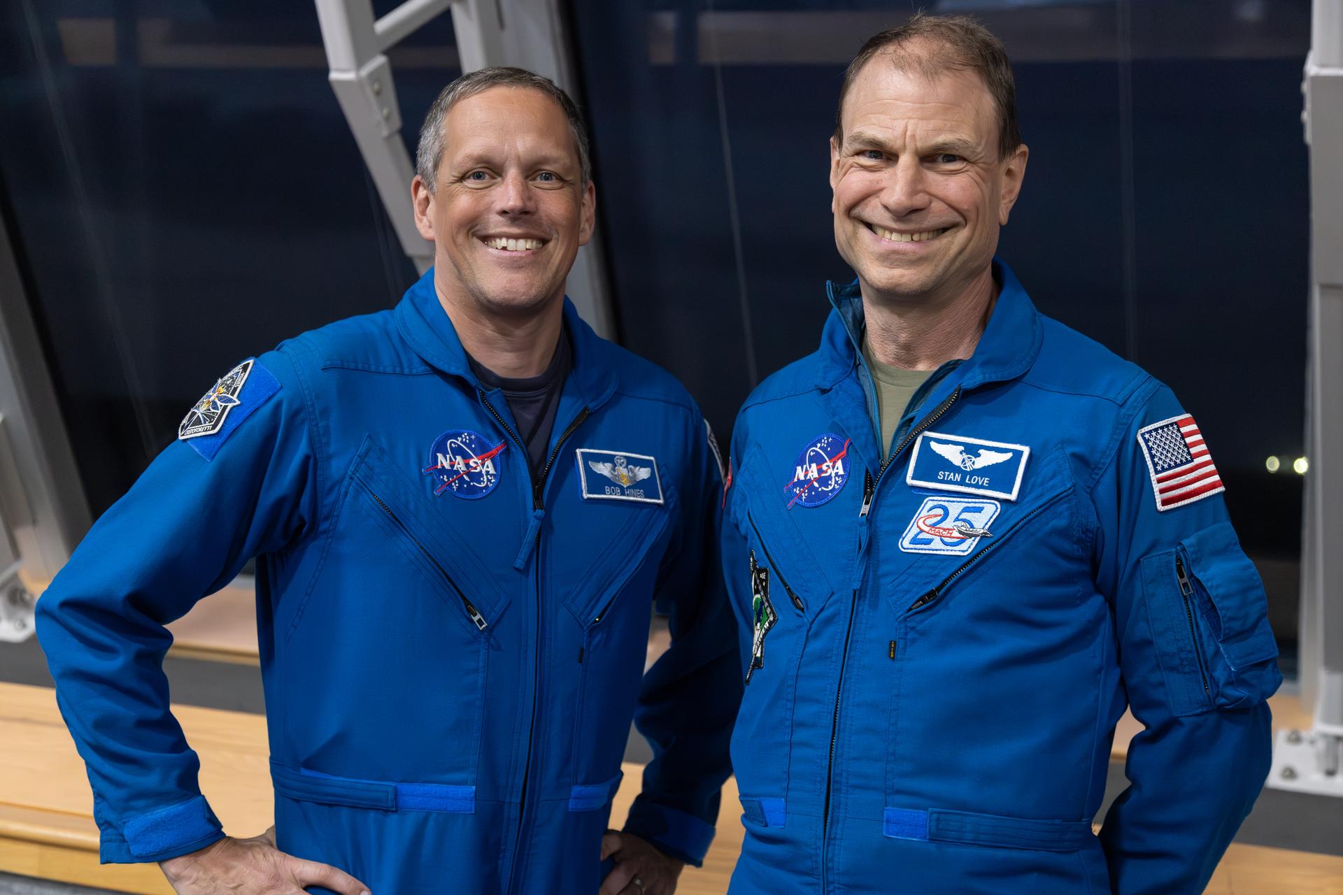 From left, NASA astronauts Bob Hines and Stan Love pose for a photograph inside Firing Room 1 of the Rocco A. Petrone Launch Control Center during the Artemis II rollout of the SLS (Space Launch System) rocket and Orion spacecraft from the Vehicle Assembly Building to Launch Complex 39B at NASA’s Kennedy Space Center in Florida on Friday, March 20, 2026. The Artemis II test flight will take Commander Reid Wiseman, Pilot Victor Glover, and Mission Specialist Christina Koch from NASA, and Mission Specialist Jeremy Hansen from the CSA (Canadian Space Agency), around the Moon and back to Earth with launch opportunities beginning in April 2026.