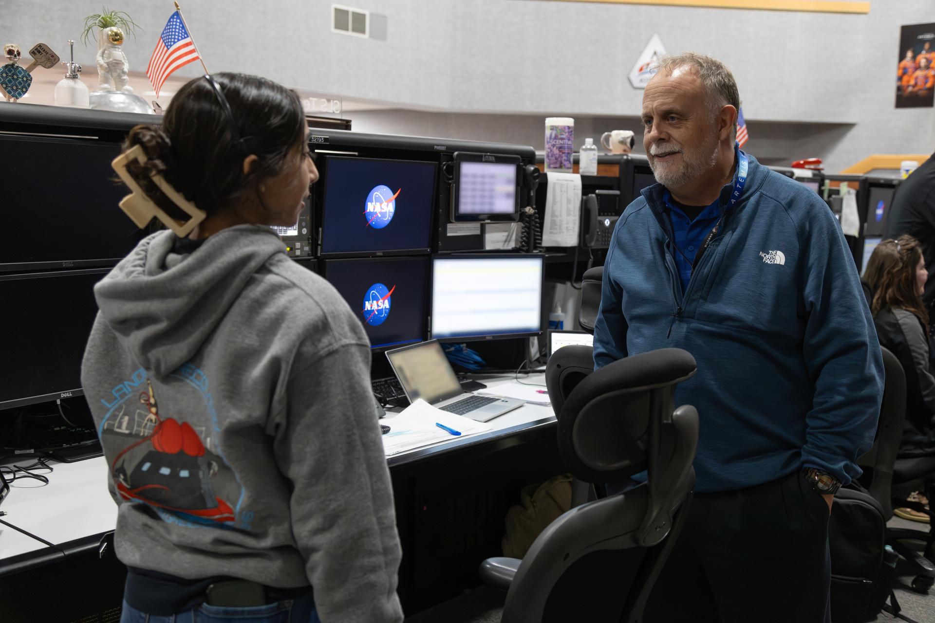 From left, an Artemis launch team member and Shawn Quinn, manager, NASA’s Exploration Ground Systems Program, talk to each other inside Firing Room 1 of the Rocco A. Petrone Launch Control Center during the Artemis II rollout of the SLS (Space Launch System) rocket and Orion spacecraft from the Vehicle Assembly Building to Launch Complex 39B at NASA’s Kennedy Space Center in Florida on Friday, March 20, 2026. The Artemis II test flight will take Commander Reid Wiseman, Pilot Victor Glover, and Mission Specialist Christina Koch from NASA, and Mission Specialist Jeremy Hansen from the CSA (Canadian Space Agency), around the Moon and back to Earth with launch opportunities beginning in April 2026.