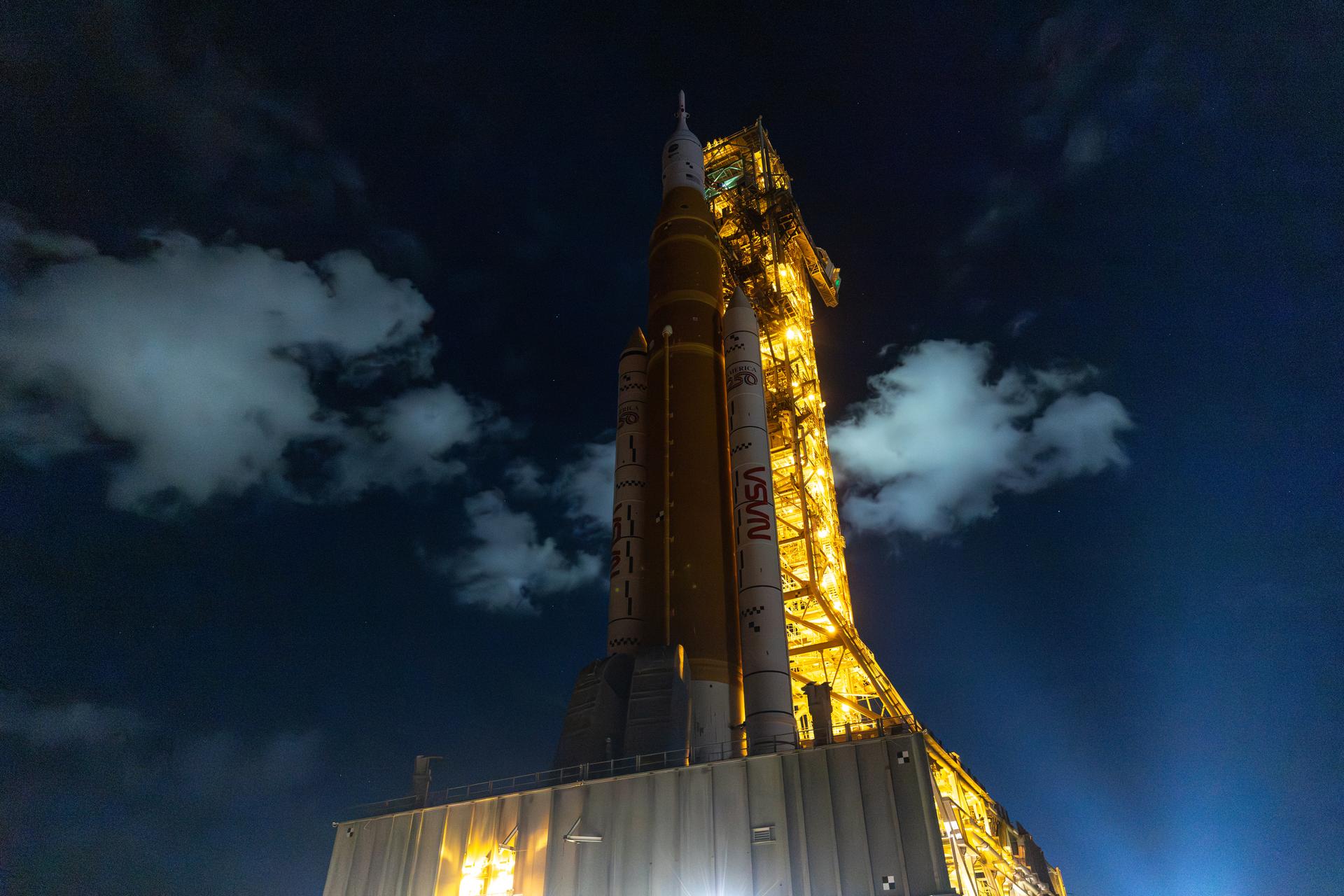 NASA’s crawler-transporter 2 carrying the agency’s Artemis II SLS (Space Launch System) rocket and Orion spacecraft, secured to the mobile launcher, begins the 4-mile journey from the Vehicle Assembly Building toward Launch Complex 39B at NASA’s Kennedy Space Center in Florida on Friday, March 20, 2026. The Artemis II test flight will take Commander Reid Wiseman, Pilot Victor Glover, and Mission Specialist Christina Koch from NASA, and Mission Specialist Jeremy Hansen from the CSA (Canadian Space Agency), around the Moon and back to Earth with launch opportunities beginning in April 2026.