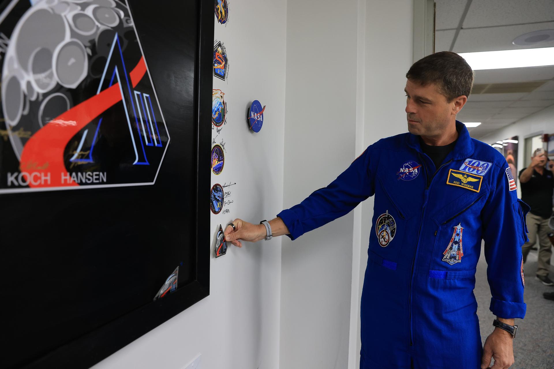 NASA’s Artemis II mission insignia is placed with other mission insignias on the wall of the Neil A. Armstrong Operations and Checkout Building at NASA’s Kennedy Space Center in Florida on Monday, March 30, 2026. It’s a tradition for any crewed mission to place their insignias on the door leaving where they have quarantined and suited up ahead of launch. The Artemis II test flight mission will take the crew on a 10-day journey around the Moon and back aboard NASA’s SLS (Space Launch System) rocket and Orion spacecraft from Launch Complex 39B no earlier than 6:24 p.m. EDT on Wednesday, April 1. 