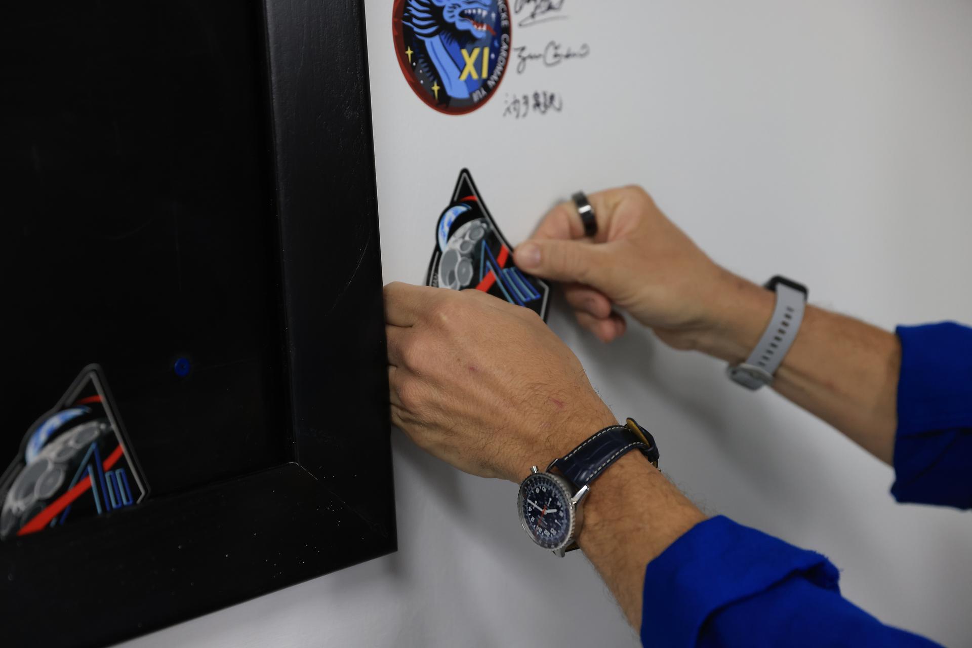 NASA’s Artemis II mission insignia is placed with other mission insignias on the wall the Neil A. Armstrong Operations and Checkout Building at NASA’s Kennedy Space Center in Florida on Monday, March 30, 2026. It’s a tradition for any crewed mission to place their insignias on the door leaving where they have quarantined and suited up ahead of launch. The Artemis II test flight mission will take the crew on a 10-day journey around the Moon and back aboard NASA’s SLS (Space Launch System) rocket and Orion spacecraft from Launch Complex 39B no earlier than 6:24 p.m. EDT on Wednesday, April 1. 