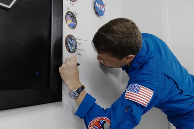 NASA astronaut Reid Wiseman, Artemis II commander, signs his name on the Arte...