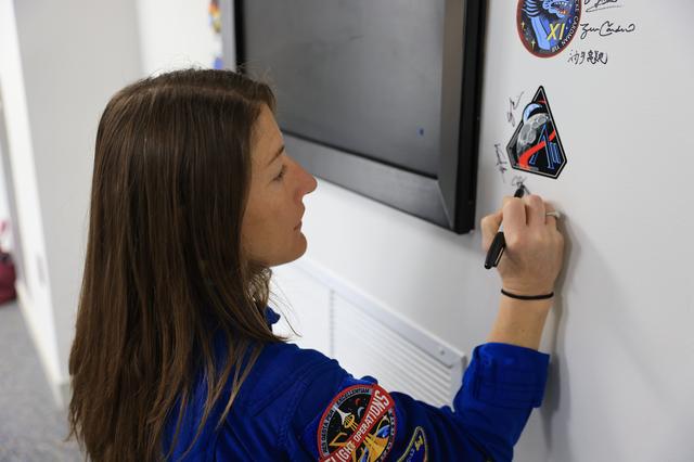 NASA astronaut Christina Koch, Artemis II mission specialist, signs her name ...