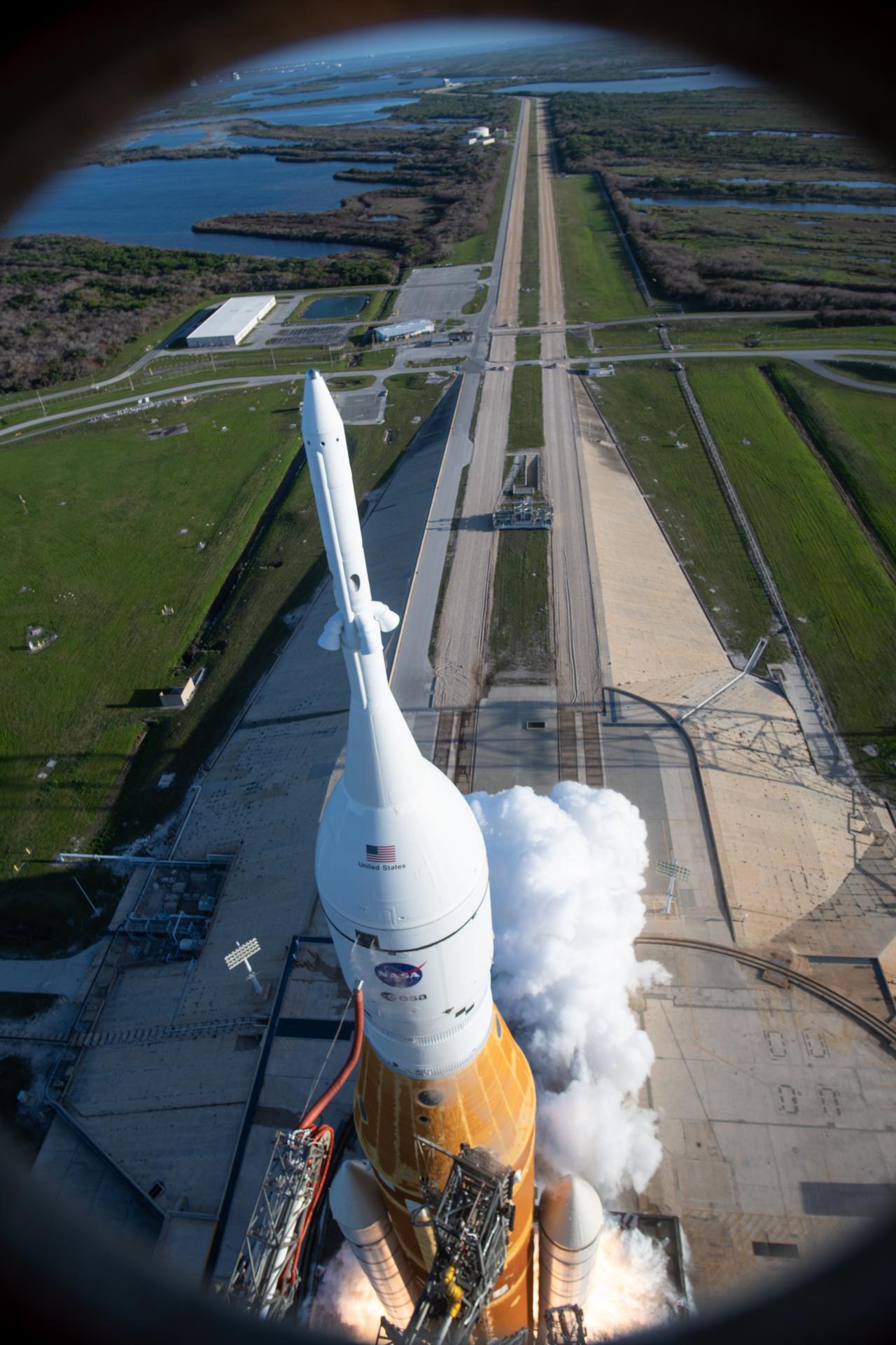 In this photograph looking down, NASA’s SLS (Space Launch System) rocket with the Orion spacecraft carrying Artemis II Commander Reid Wiseman, Pilot Victor Glover, and Mission Specialist Christina Koch from NASA, along with Mission Specialist Jeremy Hansen from the CSA (Canadian Space Agency), lifts off at 6:35 p.m. EDT on Wednesday, April 1, 2026, from Launch Complex 39B at NASA’s Kennedy Space Center I Florida. The Artemis II test flight will take the crew members on a 10-day journey around the Moon and back on Friday, April 10. 