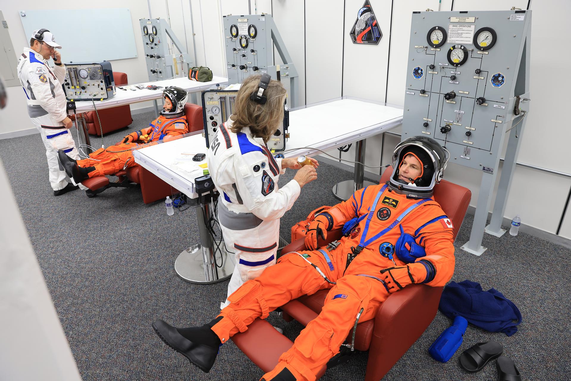 From left, Artemis II Mission Specialist Christina Koch, and Mission Specialist Jeremy Hansen from the CSA (Canadian Space Agency) complete leak checks on their spacesuits inside the crew suit-up room in the Neil A. Armstrong Operations and Checkout Building at the agency’s Kennedy Space Center in Florida on Wednesday, April 1, 2026, ahead of the Artemis II test flight. The mission will take the crew on a 10-day journey around the Moon and back aboard NASA’s SLS (Space Launch System) rocket and Orion spacecraft with a two hour launch window opening at 6:24 p.m. EDT from Launch Complex 39B at NASA Kennedy. 