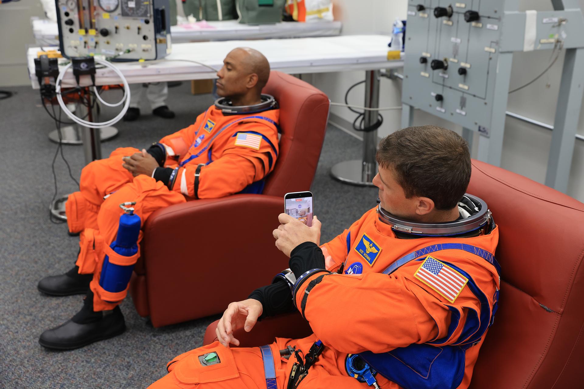From left, NASA astronauts Victor Glover, Artemis II pilot and Reid Wiseman, Artemis II commander, conduct leak checks on his spacesuit inside the crew suit-up room in the Neil A. Armstrong Operations and Checkout Building at the agency’s Kennedy Space Center in Florida on Wednesday, April 1, 2026, ahead of the Artemis II test flight. The mission will take Wiseman, Pilot Victor Glover, and Mission Specialist Christina Koch from NASA, along with Mission Specialist Jeremy Hansen from the CSA (Canadian Space Agency), on a 10-day journey around the Moon and back aboard NASA’s SLS (Space Launch System) rocket and Orion spacecraft with a two hour launch window opening at 6:24 p.m. EDT from Launch Complex 39B at NASA Kennedy. 