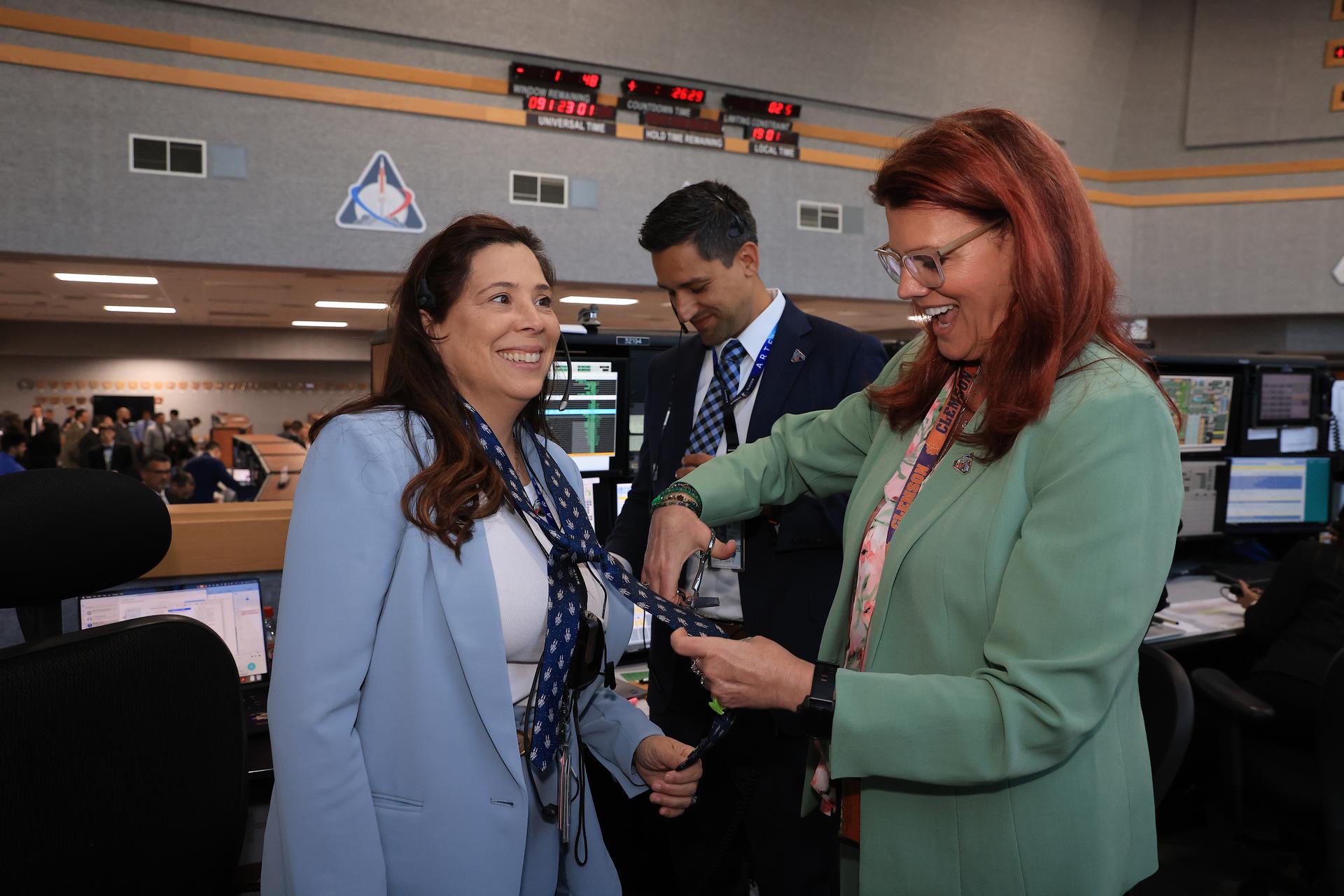 Charlie Blackwell-Thompson, Artemis launch director, cuts the tie of Liliana Villarreal, Artemis landing and recovery director, each from NASA’s Exploration Ground Systems Program, inside Firing Room 1 of the Rocco Petrone Launch Control Center following the launch of the Artemis II test flight on Wednesday, April 1, 2026. The tie-cutting is a NASA tradition for those who have a new role launch. The Artemis II mission launched Commander Reid Wiseman, Pilot Victor Glover, and Mission Specialist Christina Koch from NASA, and Mission Specialist Jeremy Hansen from the CSA (Canadian Space Agency), aboard NASA’s SLS (Space Launch System) rocket and Orion spacecraft to journey for 10 days around the Moon and back to Earth.