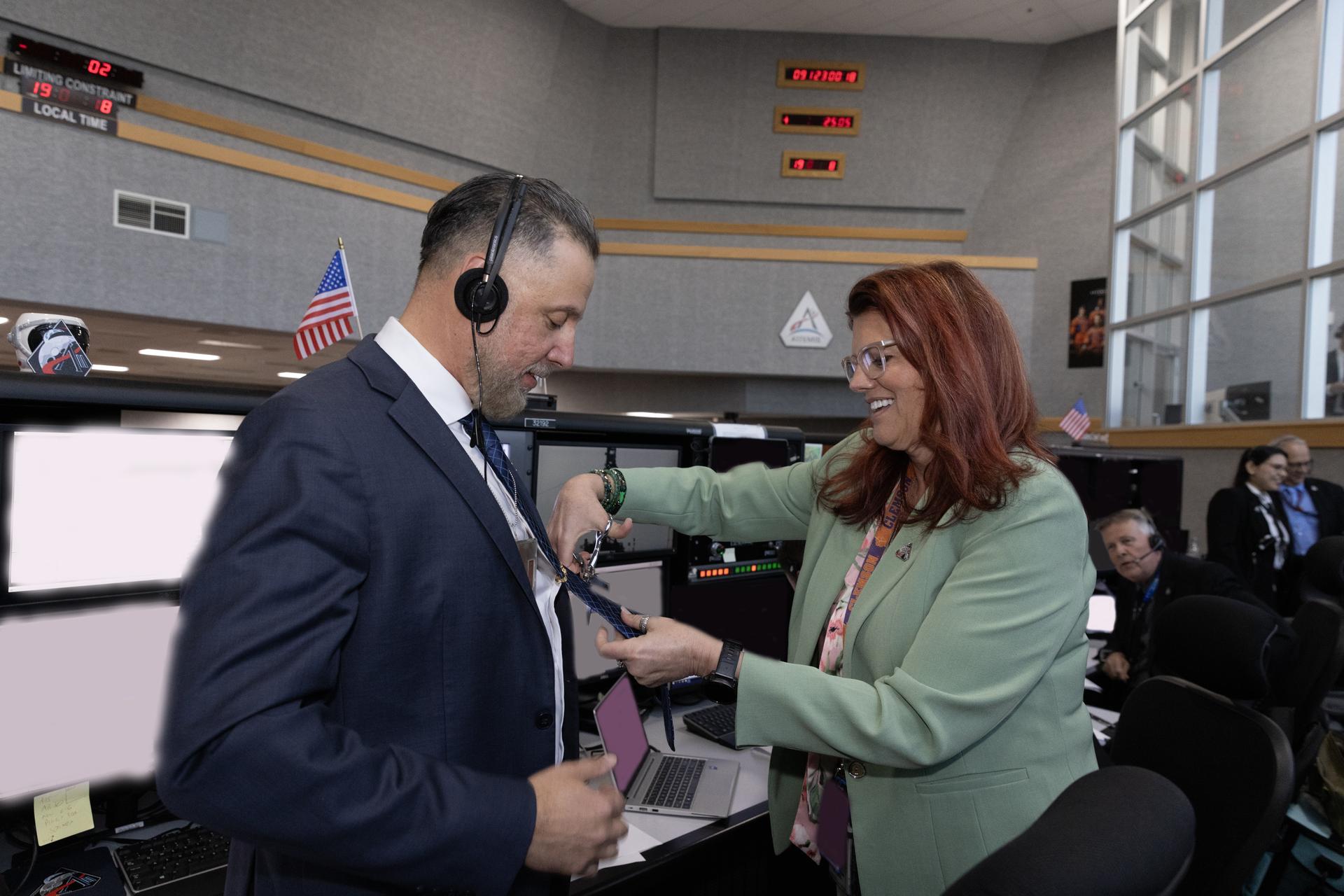 Charlie Blackwell-Thompson, Artemis launch director, cuts the tie of Carlos Monge, branch chief of the Test, Launch, and Recovery Operations, each from NASA’s Exploration Ground Systems Program, inside Firing Room 1 of the Rocco Petrone Launch Control Center following the launch of the Artemis II test flight on Wednesday, April 1, 2026. The tie-cutting is a NASA tradition those who have a new role launch. The Artemis II mission launched Commander Reid Wiseman, Pilot Victor Glover, and Mission Specialist Christina Koch from NASA, and Mission Specialist Jeremy Hansen from the CSA (Canadian Space Agency), aboard NASA’s SLS (Space Launch System) rocket and Orion spacecraft to journey for 10 days around the Moon and back to Earth.