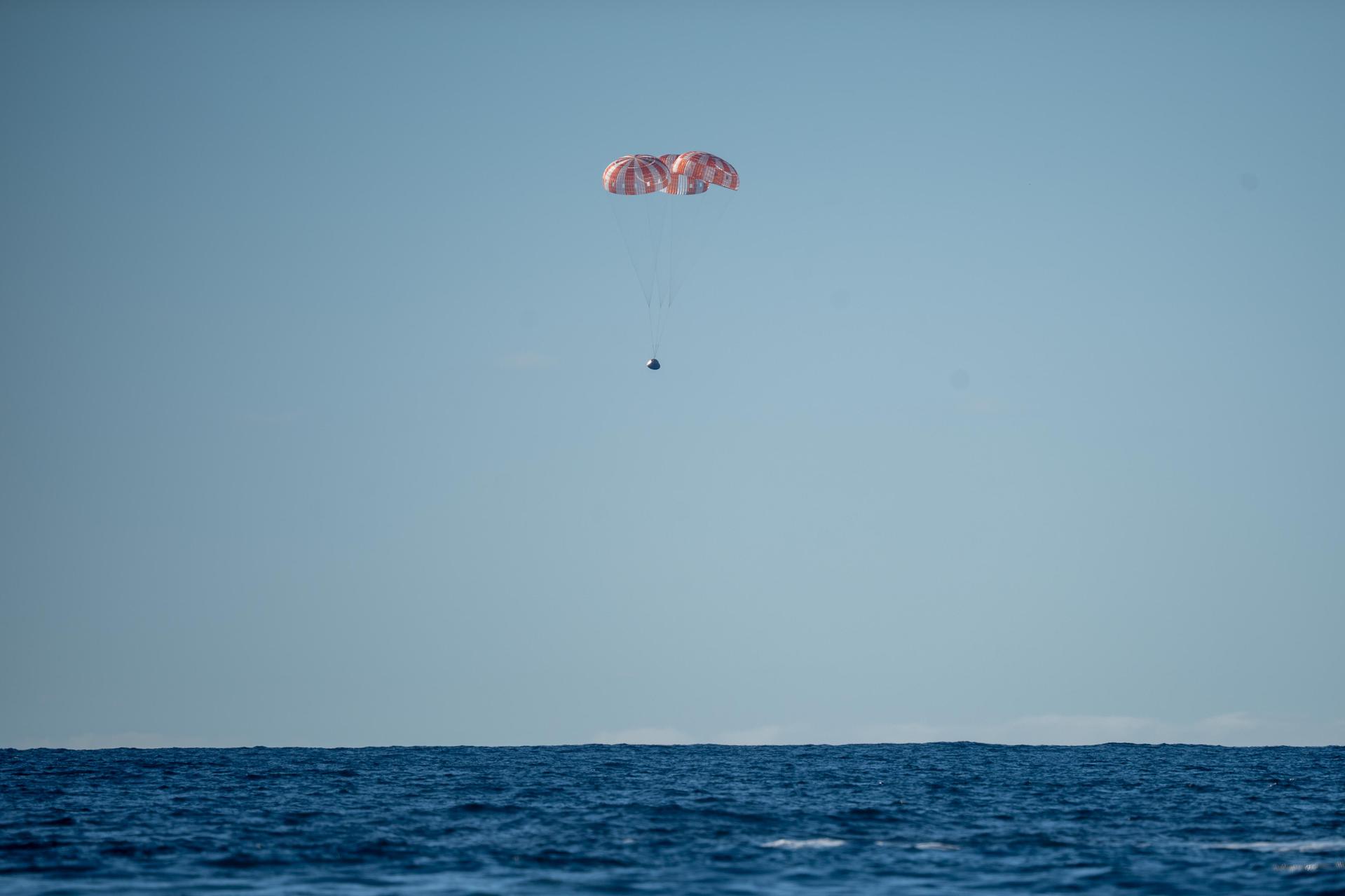 Parachutes secured to NASA’s Orion spacecraft deploy before splashdown in the Pacific Ocean near San Diego, California, on Friday, April 10, 2026, for the Artemis II test flight. The Artemis II mission carrying Artemis II Commander Reid Wiseman, Pilot Victor Glover, and Mission Specialist Christina Koch from NASA, along with Mission Specialist Jeremy Hansen from the CSA (Canadian Space Agency), launched on Wednesday, April 1, from NASA’s Kennedy Space Center in Florida to begin its 10-day journey around the Moon for scientific discovery, economic benefits, and to build on our foundation for the first crewed missions to Mars. NASA’s Landing and Recovery team and the U.S. military are coordinating efforts to extract the Artemis II crew from Orion.