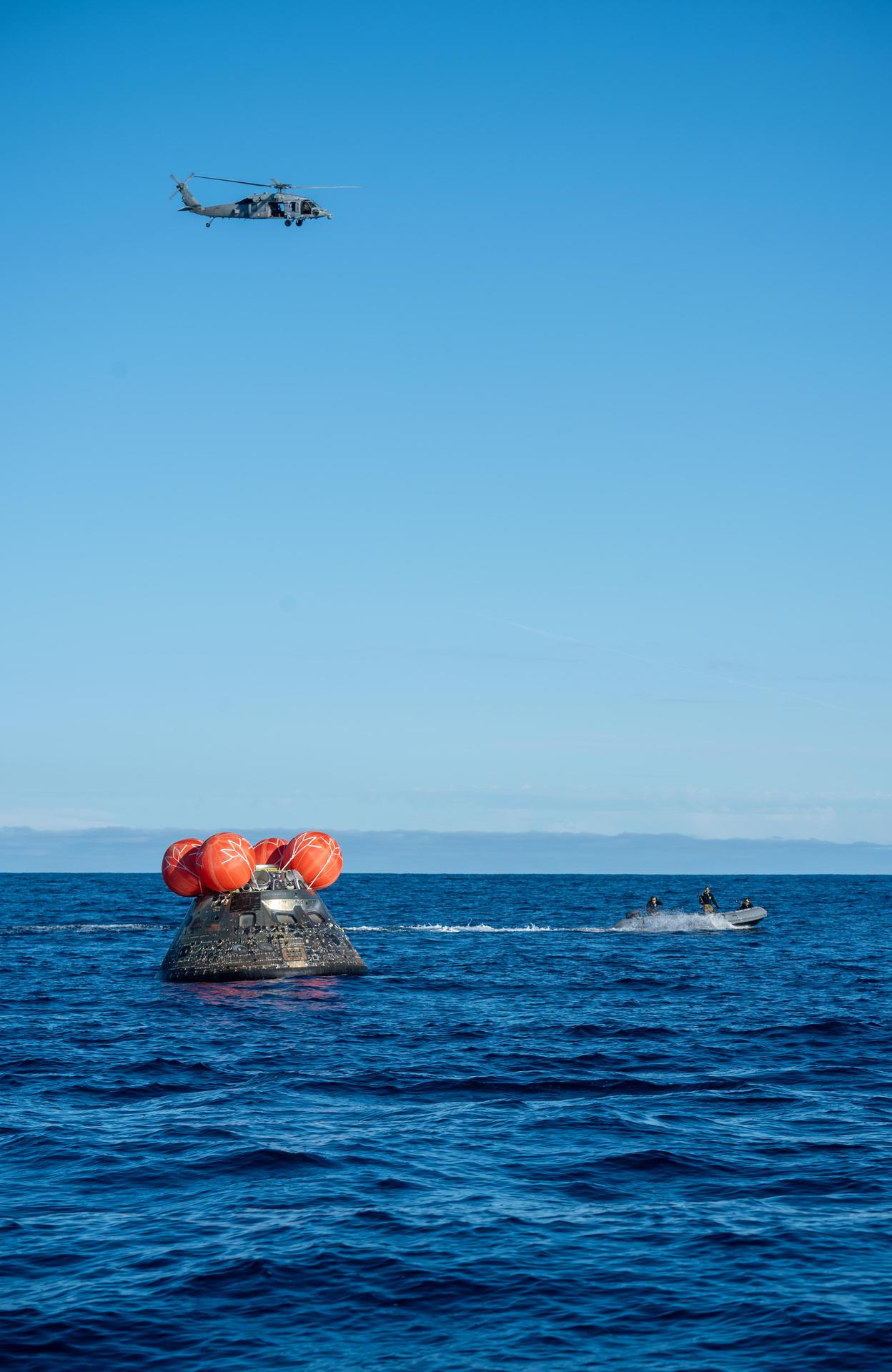 NASA's Orion spacecraft carrying Artemis II Commander Reid Wiseman, Pilot Victor Glover, and Mission Specialist Christina Koch from NASA, along with Mission Specialist Jeremy Hansen from the CSA (Canadian Space Agency), floats in the Pacific Ocean near San Diego, California, at 5:07 p.m. PDT, (8:07 p.m. EDT) on Friday, April 10, 2026. NASA’s Landing and Recovery team and U.S. Navy personnel aboard an inflatable raft and a H60-S Seahawk helicopter hovers above to communicate Orion’s location back to USS John P. Murtha to coordinate efforts to secure the spacecraft in the well deck of the ship. The Artemis II test flight launched on Wednesday, April 1, from NASA’s Kennedy Space Center in Florida to begin its 10-day journey around the Moon for scientific discovery, economic benefits, and to build on our foundation for the first crewed missions to Mars.