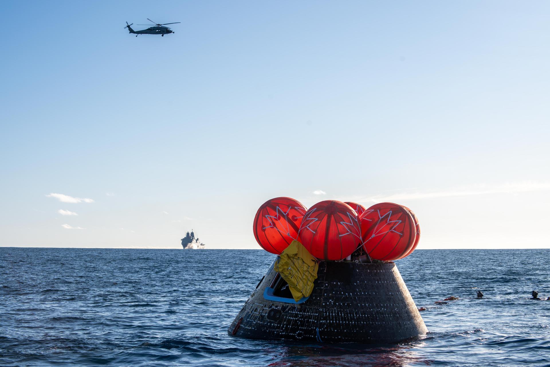 NASA's Orion spacecraft carrying Artemis II Commander Reid Wiseman, Pilot Victor Glover, and Mission Specialist Christina Koch from NASA, along with Mission Specialist Jeremy Hansen from the CSA (Canadian Space Agency), floats in the Pacific Ocean near San Diego, California, at 5:07 p.m. PDT, (8:07 p.m. EDT) on Friday, April 10, 2026. NASA’s Landing and Recovery team and U.S. Navy personnel aboard an inflatable raft, called the front porch, and a H60-S Seahawk helicopter hovers above to communicate Orion’s location back to USS John P. Murtha to coordinate efforts to secure the spacecraft in the well deck of the ship. The Artemis II test flight launched on Wednesday, April 1, from NASA’s Kennedy Space Center in Florida to begin its 10-day journey around the Moon for scientific discovery, economic benefits, and to build on our foundation for the first crewed missions to Mars.