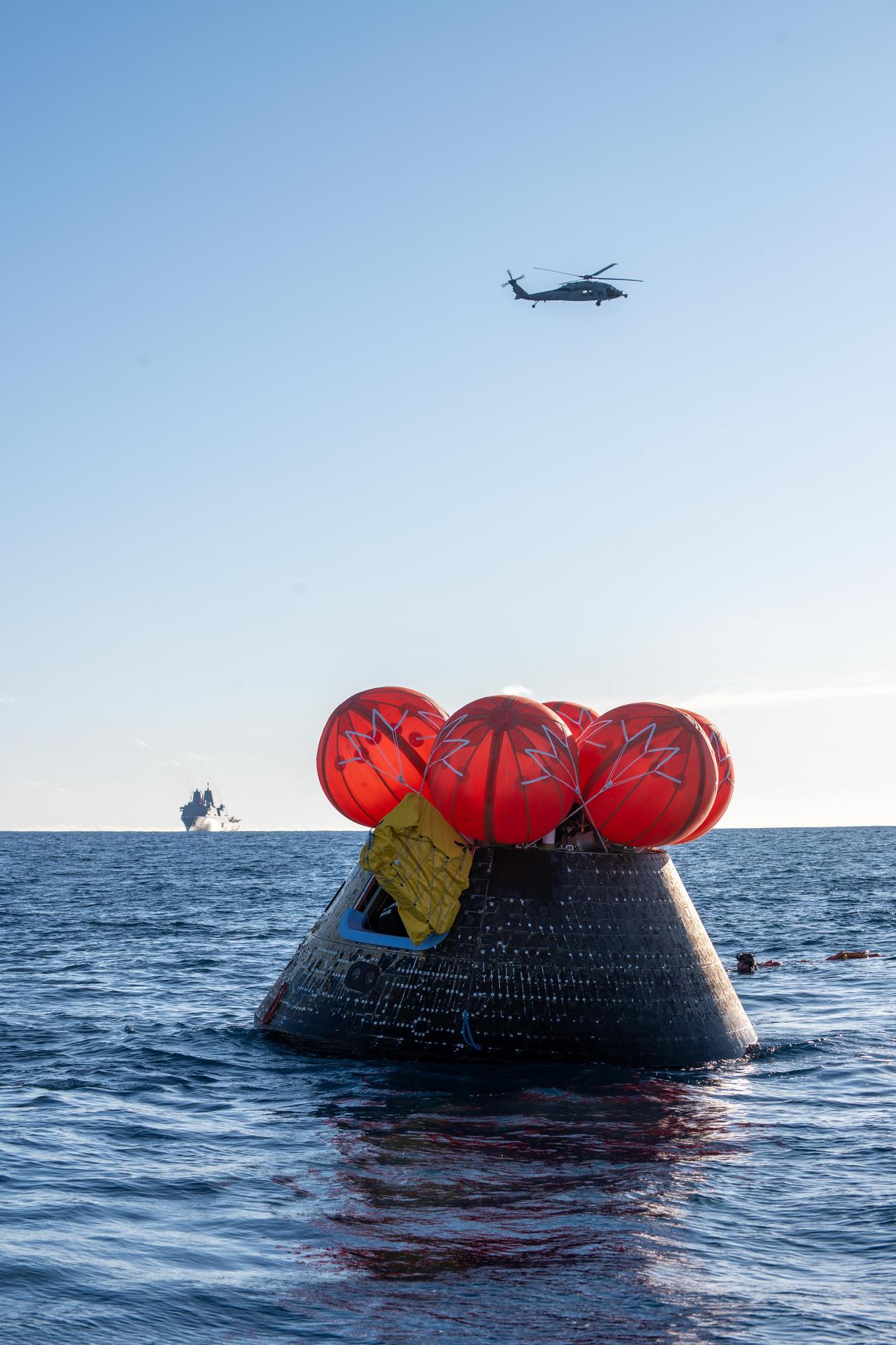 NASA's Orion spacecraft carrying Artemis II Commander Reid Wiseman, Pilot Victor Glover, and Mission Specialist Christina Koch from NASA, along with Mission Specialist Jeremy Hansen from the CSA (Canadian Space Agency), floats in the Pacific Ocean near San Diego, California, at 5:07 p.m. PDT, (8:07 p.m. EDT) on Friday, April 10, 2026. NASA’s Landing and Recovery team and U.S. Navy personnel aboard an inflatable raft, called the front porch, and a H60-S Seahawk helicopter hovers above to communicate Orion’s location back to USS John P. Murtha to coordinate efforts to secure the spacecraft in the well deck of the ship. The Artemis II test flight launched on Wednesday, April 1, from NASA’s Kennedy Space Center in Florida to begin its 10-day journey around the Moon for scientific discovery, economic benefits, and to build on our foundation for the first crewed missions to Mars.