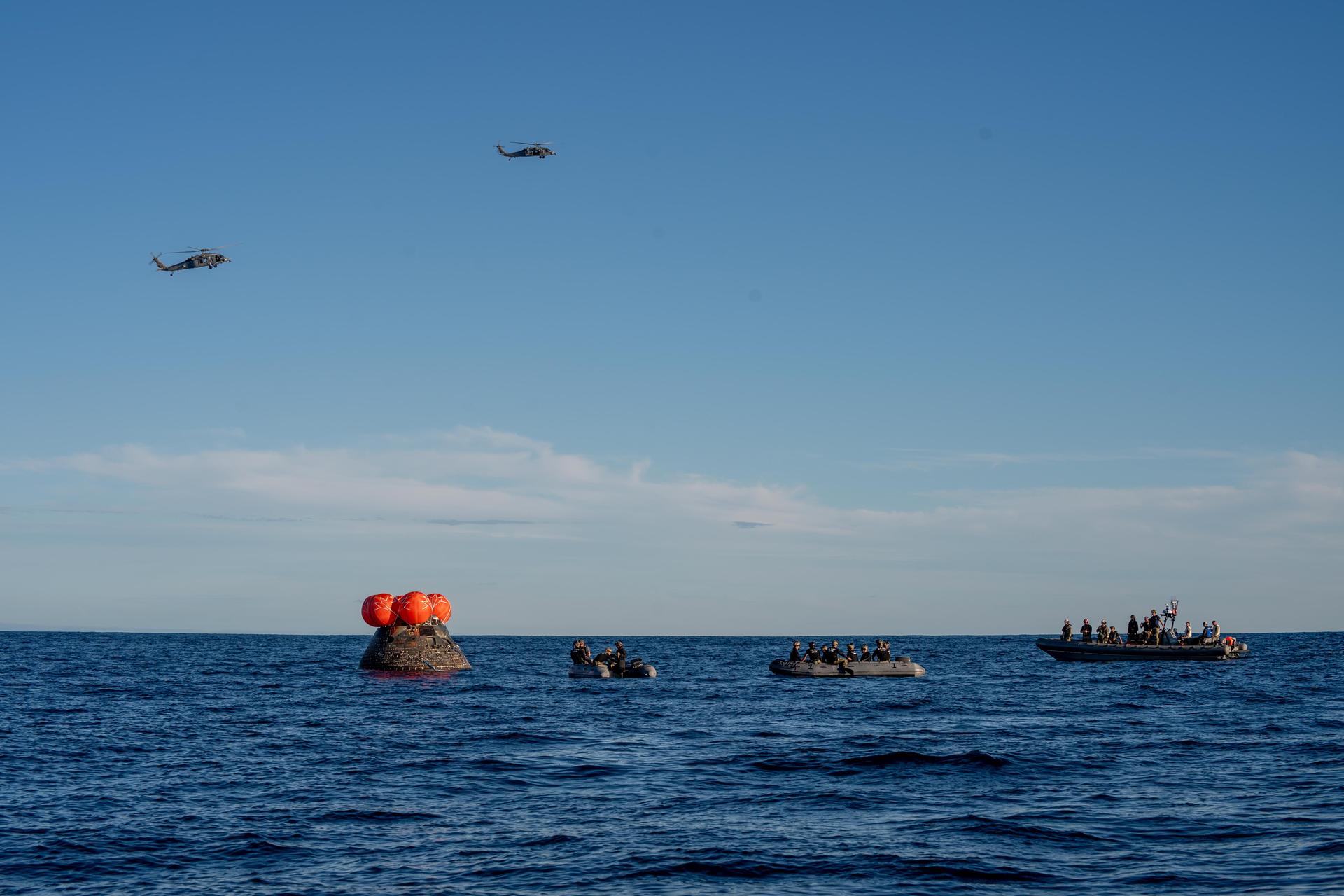 NASA's Orion spacecraft carrying Artemis II Commander Reid Wiseman, Pilot Victor Glover, and Mission Specialist Christina Koch from NASA, along with Mission Specialist Jeremy Hansen from the CSA (Canadian Space Agency), floats in the Pacific Ocean near San Diego, California, at 5:07 p.m. PDT, (8:07 p.m. EDT) on Friday, April 10, 2026. NASA’s Landing and Recovery team and U.S. Navy personnel aboard an inflatable raft, called the front porch, and a H60-S Seahawk helicopter hovers above to communicate Orion’s location back to USS John P. Murtha to coordinate efforts to secure the spacecraft in the well deck of the ship. The Artemis II test flight launched on Wednesday, April 1, from NASA’s Kennedy Space Center in Florida to begin its 10-day journey around the Moon for scientific discovery, economic benefits, and to build on our foundation for the first crewed missions to Mars.