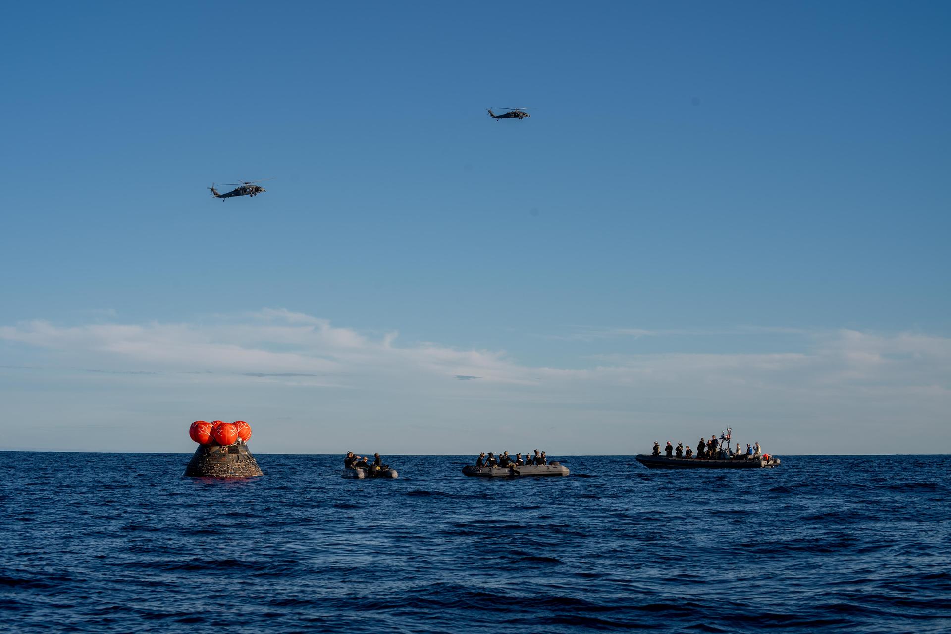 NASA's Orion spacecraft carrying Artemis II Commander Reid Wiseman, Pilot Victor Glover, and Mission Specialist Christina Koch from NASA, along with Mission Specialist Jeremy Hansen from the CSA (Canadian Space Agency), floats in the Pacific Ocean near San Diego, California, at 5:07 p.m. PDT, (8:07 p.m. EDT) on Friday, April 10, 2026. NASA’s Landing and Recovery team and U.S. Navy personnel aboard an inflatable raft, called the front porch, and a H60-S Seahawk helicopter hovers above to communicate Orion’s location back to USS John P. Murtha to coordinate efforts to secure the spacecraft in the well deck of the ship. The Artemis II test flight launched on Wednesday, April 1, from NASA’s Kennedy Space Center in Florida to begin its 10-day journey around the Moon for scientific discovery, economic benefits, and to build on our foundation for the first crewed missions to Mars.