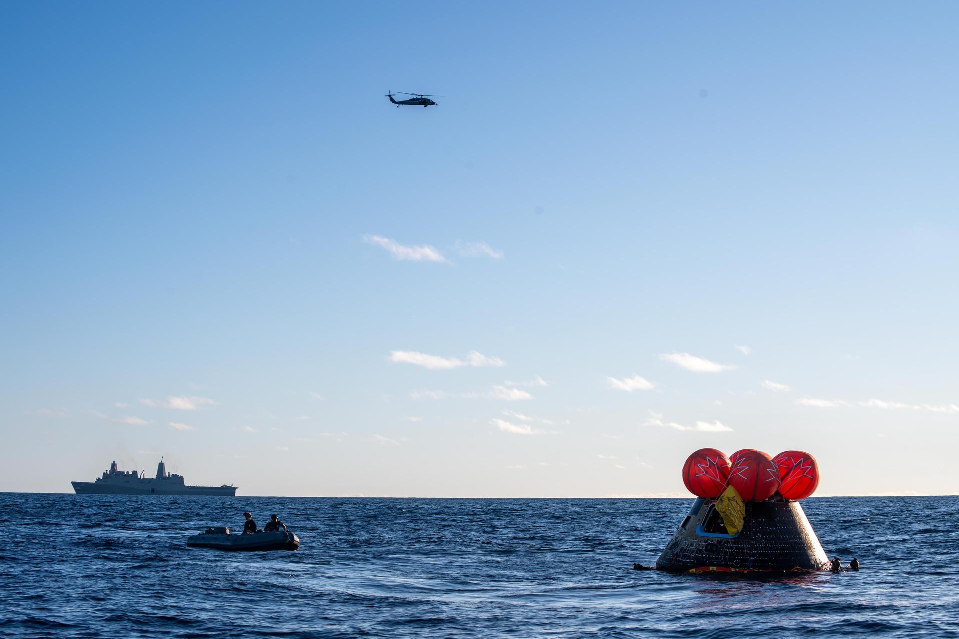 NASA's Orion spacecraft carrying Artemis II Commander Reid Wiseman, Pilot Victor Glover, and Mission Specialist Christina Koch from NASA, along with Mission Specialist Jeremy Hansen from the CSA (Canadian Space Agency), floats in the Pacific Ocean near San Diego, California, at 5:07 p.m. PDT, (8:07 p.m. EDT) on Friday, April 10, 2026. NASA’s Landing and Recovery team and U.S. Navy personnel aboard an inflatable raft, called the front porch, and a H60-S Seahawk helicopter hovers above to communicate Orion’s location back to USS John P. Murtha to coordinate efforts to secure the spacecraft in the well deck of the ship. The Artemis II test flight launched on Wednesday, April 1, from NASA’s Kennedy Space Center in Florida to begin its 10-day journey around the Moon for scientific discovery, economic benefits, and to build on our foundation for the first crewed missions to Mars.