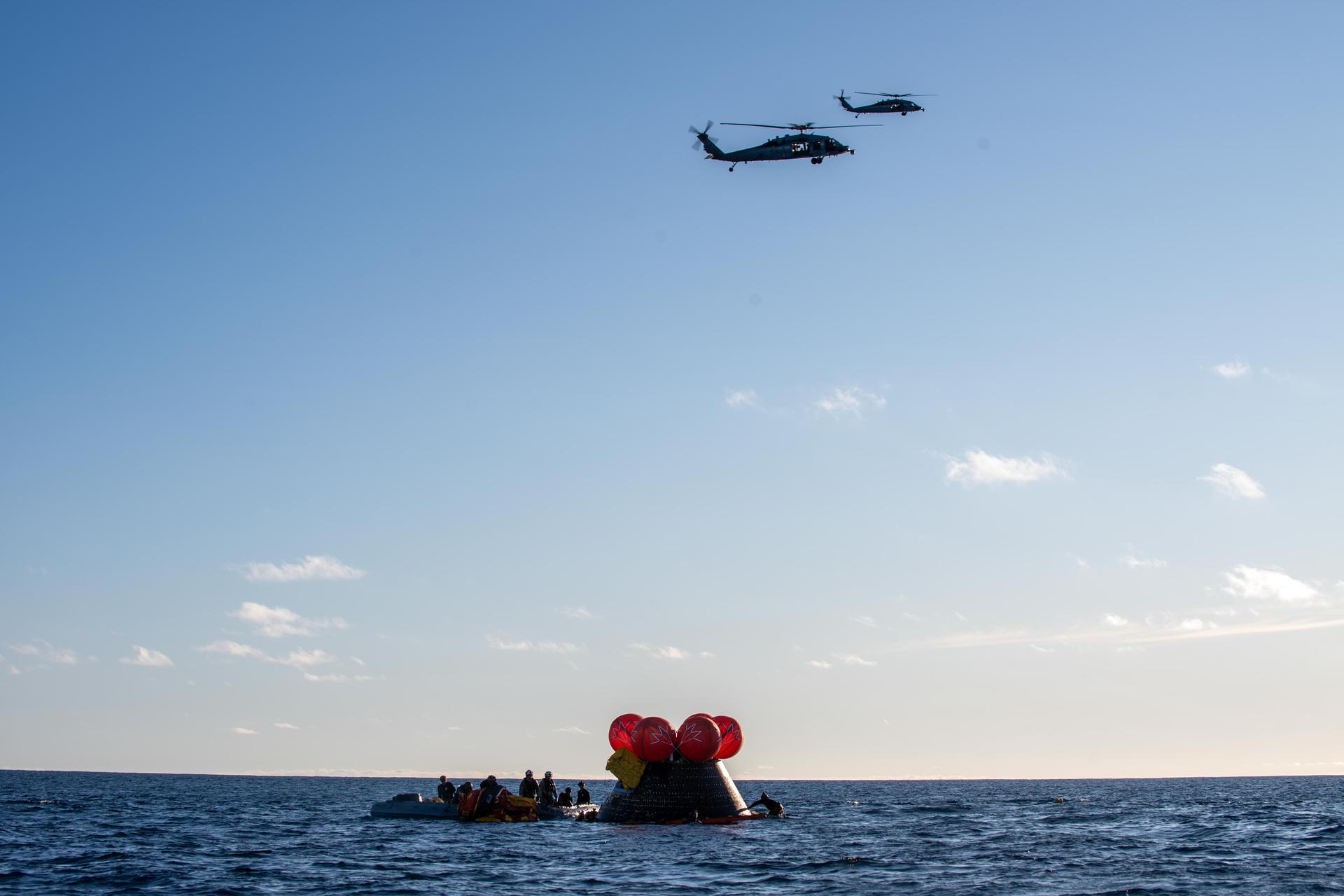 NASA's Orion spacecraft carrying Artemis II Commander Reid Wiseman, Pilot Victor Glover, and Mission Specialist Christina Koch from NASA, along with Mission Specialist Jeremy Hansen from the CSA (Canadian Space Agency), floats in the Pacific Ocean near San Diego, California, at 5:07 p.m. PDT, (8:07 p.m. EDT) on Friday, April 10, 2026. NASA’s Landing and Recovery team and U.S. Navy personnel aboard an inflatable raft, called the front porch, and a H60-S Seahawk helicopter hovers above to communicate Orion’s location back to USS John P. Murtha to coordinate efforts to secure the spacecraft in the well deck of the ship. The Artemis II test flight launched on Wednesday, April 1, from NASA’s Kennedy Space Center in Florida to begin its 10-day journey around the Moon for scientific discovery, economic benefits, and to build on our foundation for the first crewed missions to Mars.