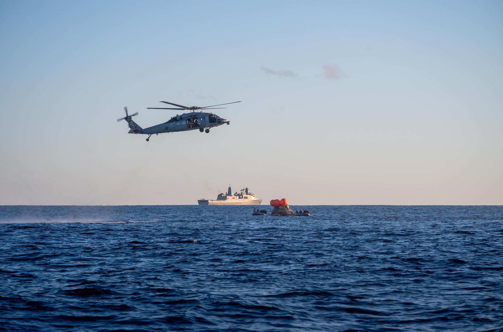 NASA's Orion spacecraft carrying Artemis II Commander Reid Wiseman, Pilot Victor Glover, and Mission Specialist Christina Koch from NASA, along with Mission Specialist Jeremy Hansen from the CSA (Canadian Space Agency), floats in the Pacific Ocean near San Diego, California, at 5:07 p.m. PDT, (8:07 p.m. EDT) on Friday, April 10, 2026. NASA’s Landing and Recovery team and U.S. Navy personnel aboard an inflatable raft, called the front porch, and a H60-S Seahawk helicopter hovers above to communicate Orion’s location back to USS John P. Murtha to coordinate efforts to secure the spacecraft in the well deck of the ship. The Artemis II test flight launched on Wednesday, April 1, from NASA’s Kennedy Space Center in Florida to begin its 10-day journey around the Moon for scientific discovery, economic benefits, and to build on our foundation for the first crewed missions to Mars.
