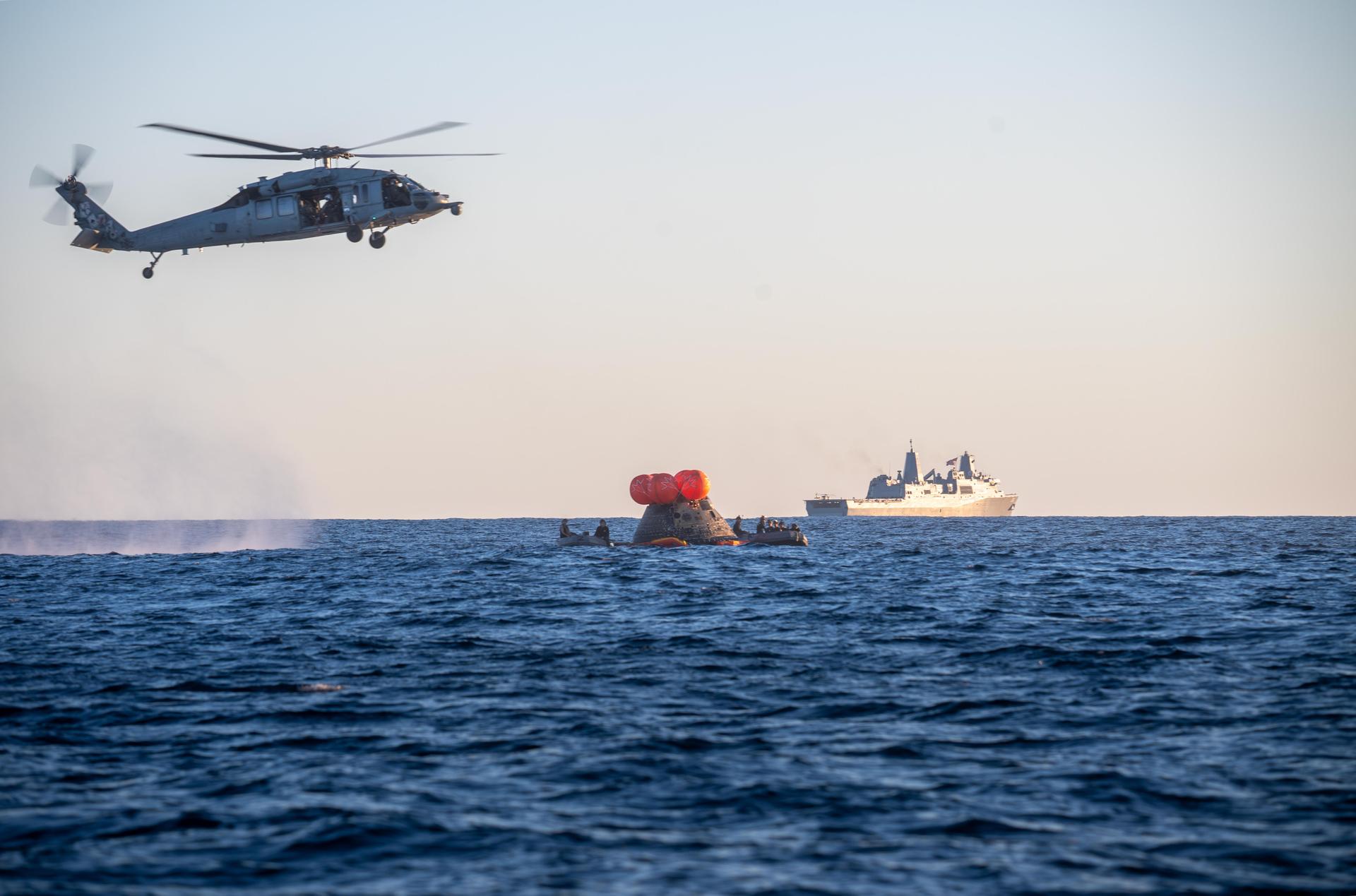 NASA's Orion spacecraft carrying Artemis II Commander Reid Wiseman, Pilot Victor Glover, and Mission Specialist Christina Koch from NASA, along with Mission Specialist Jeremy Hansen from the CSA (Canadian Space Agency), floats in the Pacific Ocean near San Diego, California, at 5:07 p.m. PDT, (8:07 p.m. EDT) on Friday, April 10, 2026. NASA’s Landing and Recovery team and U.S. Navy personnel aboard an inflatable raft, called the front porch, and a H60-S Seahawk helicopter hovers above to communicate Orion’s location back to USS John P. Murtha to coordinate efforts to secure the spacecraft in the well deck of the ship. The Artemis II test flight launched on Wednesday, April 1, from NASA’s Kennedy Space Center in Florida to begin its 10-day journey around the Moon for scientific discovery, economic benefits, and to build on our foundation for the first crewed missions to Mars.