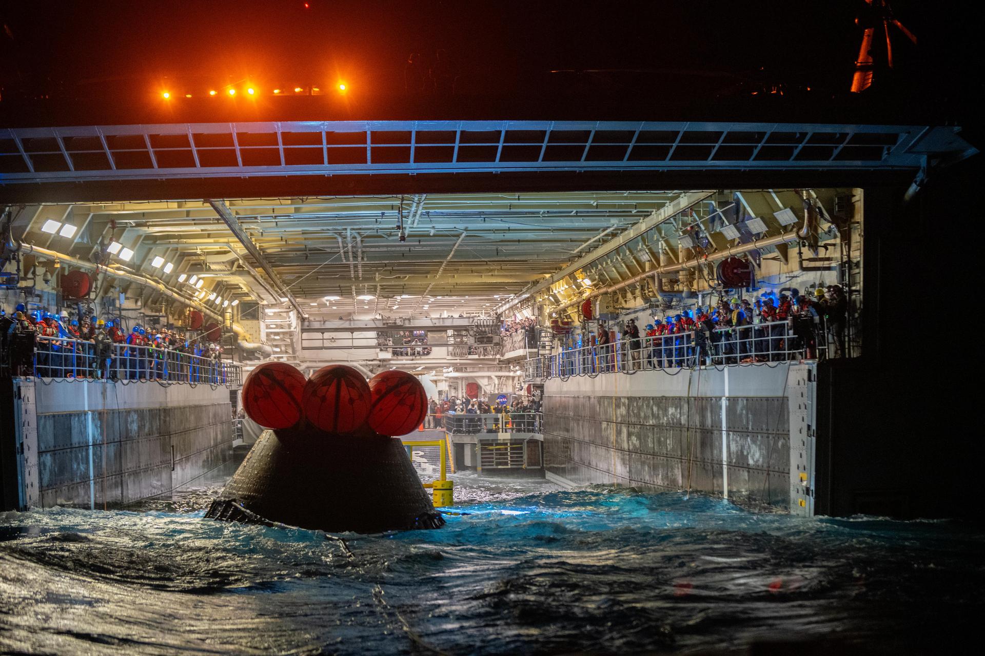 NASA’s Landing and Recovery team and U.S. Navy personnel tow and secure NASA’s Orion spacecraft in the well deck of the USS John P. Murtha following splashdown in the Pacific Ocean near San Diego, California, at 5:07 p.m. PDT, (8:07 p.m. EDT) on Friday, April 10, 2026, after the Artemis II test flight. The Artemis II mission carrying Artemis II Commander Reid Wiseman, Pilot Victor Glover, and Mission Specialist Christina Koch from NASA, along with Mission Specialist Jeremy Hansen from the CSA (Canadian Space Agency), launched on Wednesday, April 1, from NASA’s Kennedy Space Center in Florida to begin its 10-day journey around the Moon for scientific discovery, economic benefits, and to build on our foundation for the first crewed missions to Mars. 